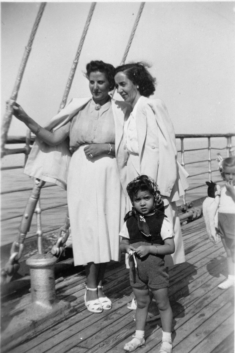 A Greek Jewish family stands on board a ship.