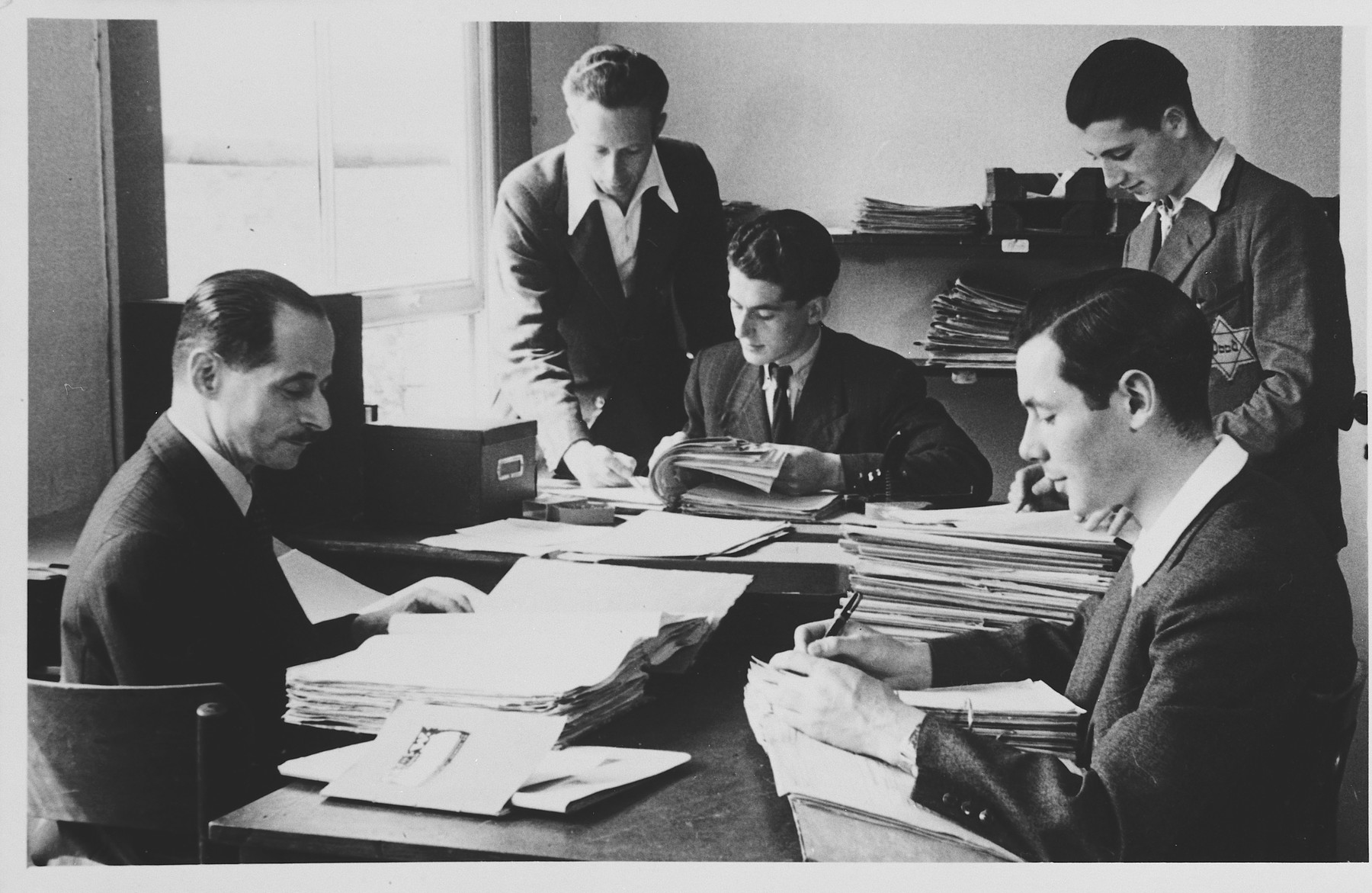 Dutch Jews, some wearing Jewish Stars, work in the newspaper office.

Pictured on the far left is Kurt Zielenziger.