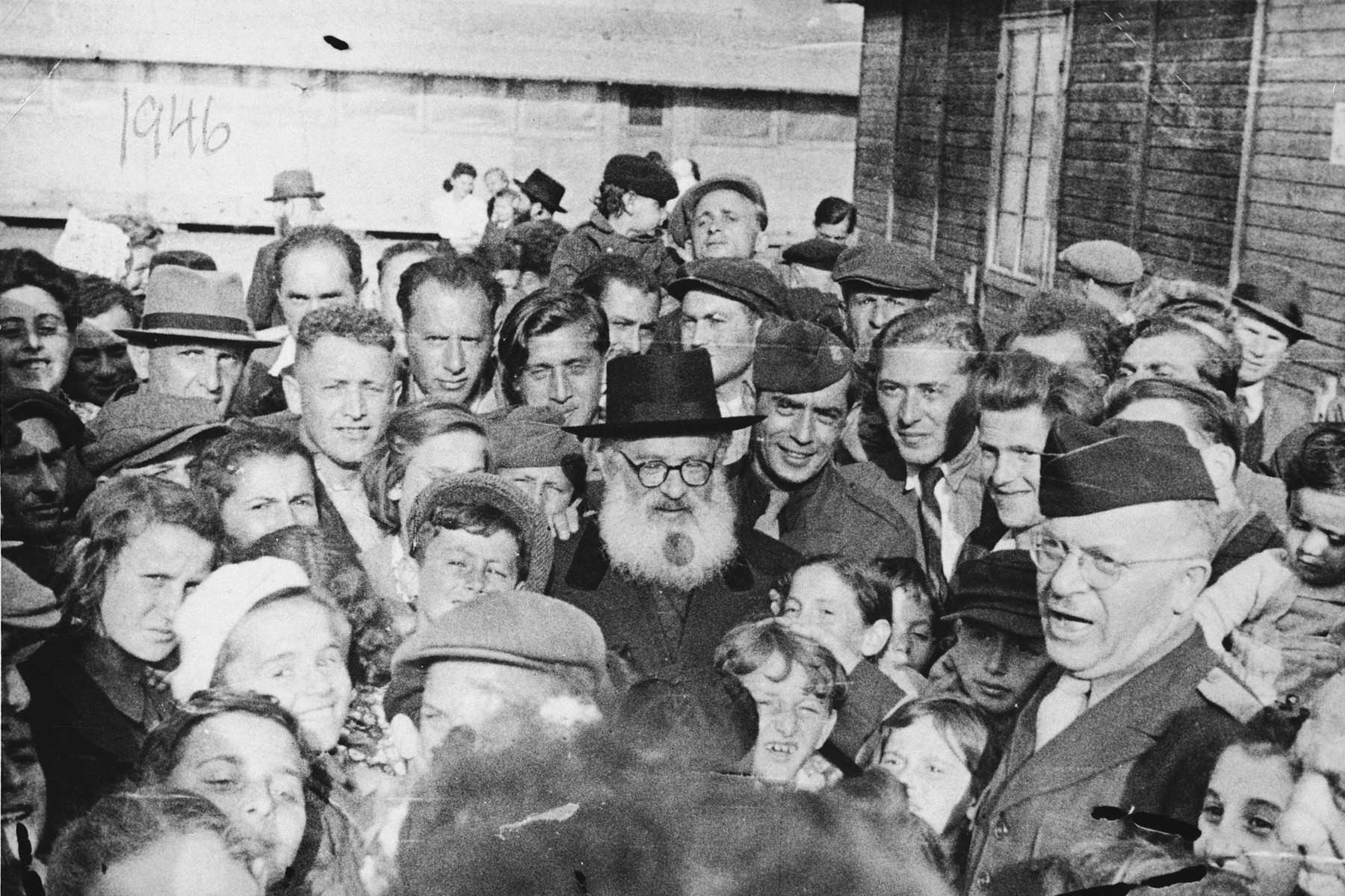 Rabbi Isaac Herzog pays an official visit to the Neu Freimann displaced person's camp.

Among the children crowded around him is Lova Warszawczyk.