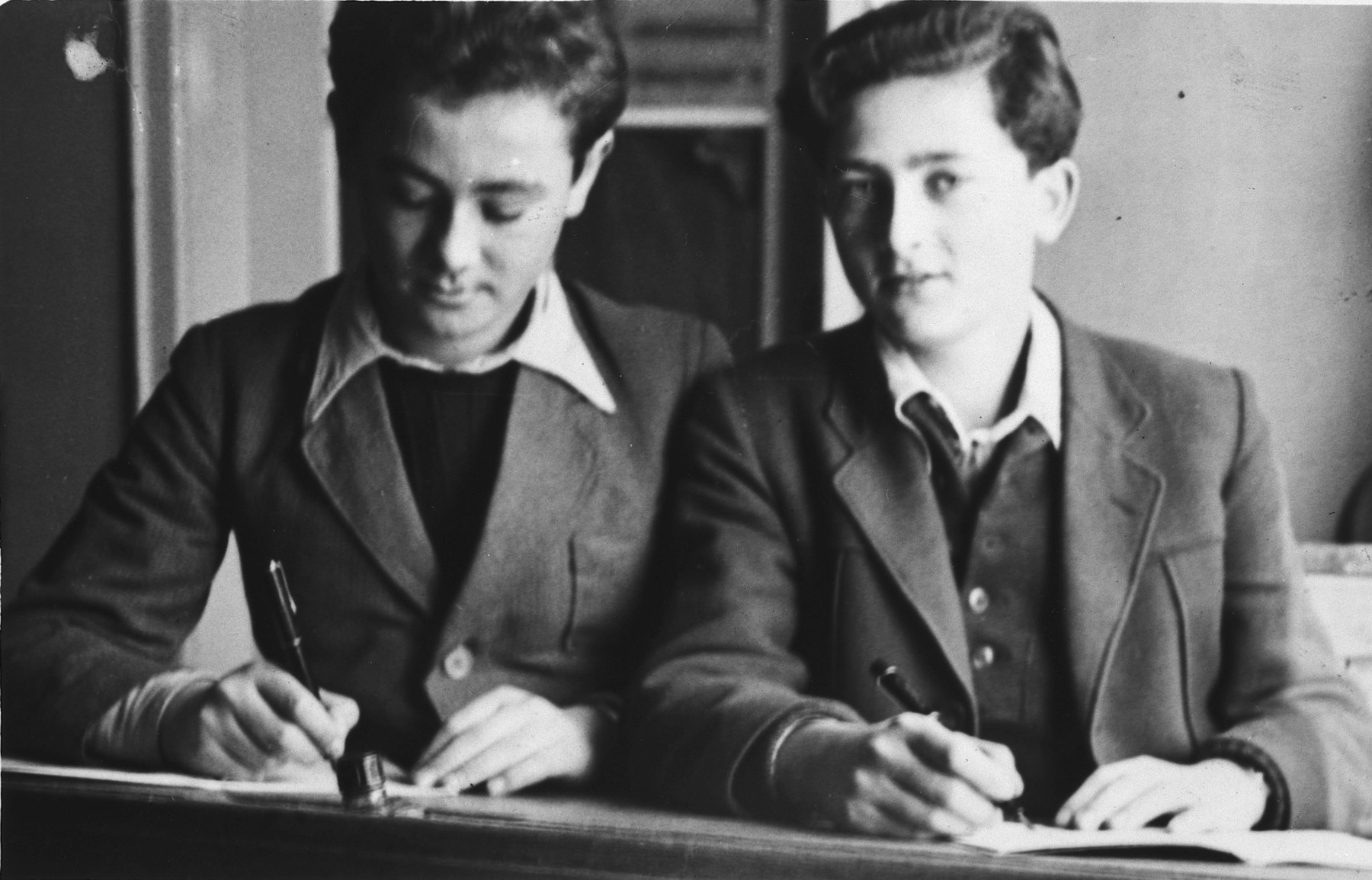 Two school boys work at their desk in the Stuttgart displaced persons camp.

Lova Warszawczyk is on the left; Jack Krampf is on the right.