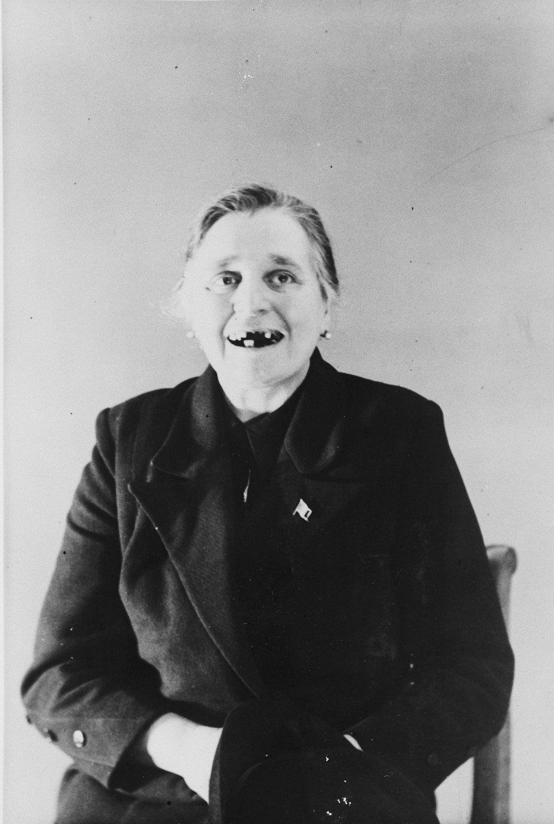 A female survivor shows her missing teeth as a result of her incarceration in the Breendonck internment camp.