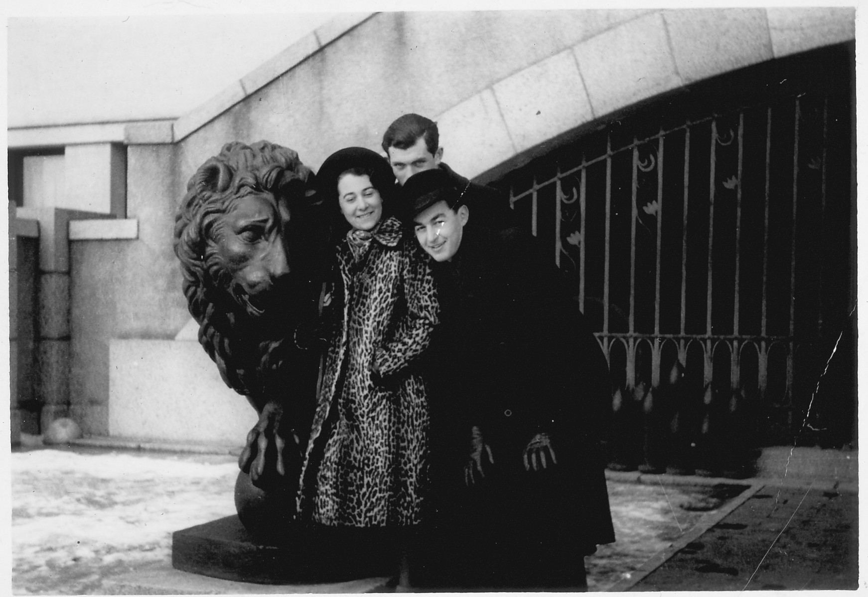 Hanni Sondheimer, Liusa Joffe and Herman Berlovic stand by a statue of a lion in Kaunas at the War Museum.