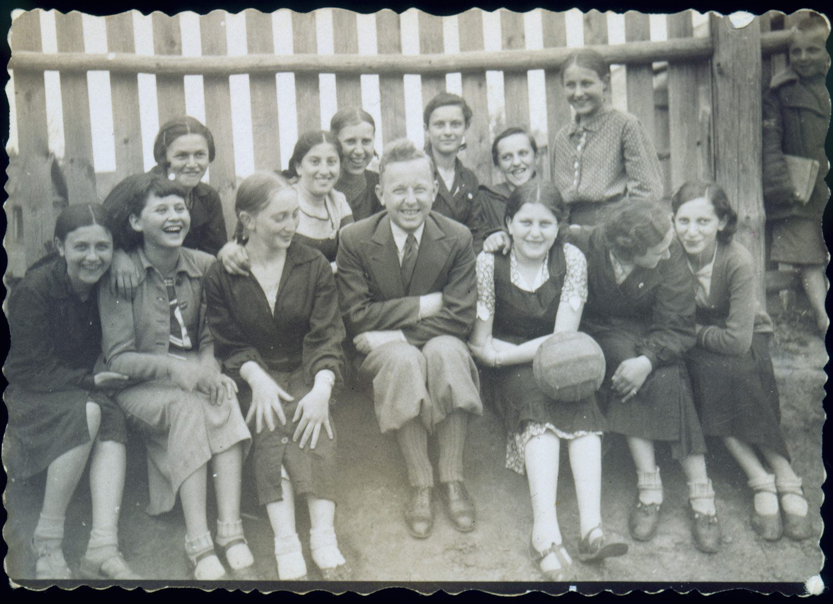 Group portrait of students in a physical education class at a Polish secondary school.  

Among those pictured are: Chaya Szepsenwol (front row holding a volleyball); Fejga Szepsenwol (back row, second from the left); and Gala Rogovin (front row, third from the left).