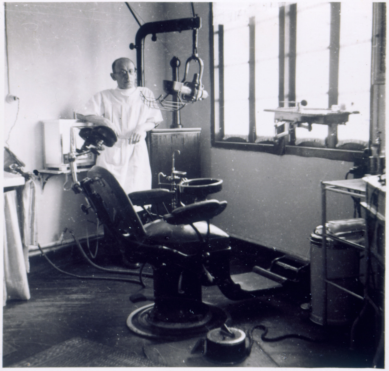 Dr. Mannes, a Jewish refugee dentist, stands in his office in Shanghai.