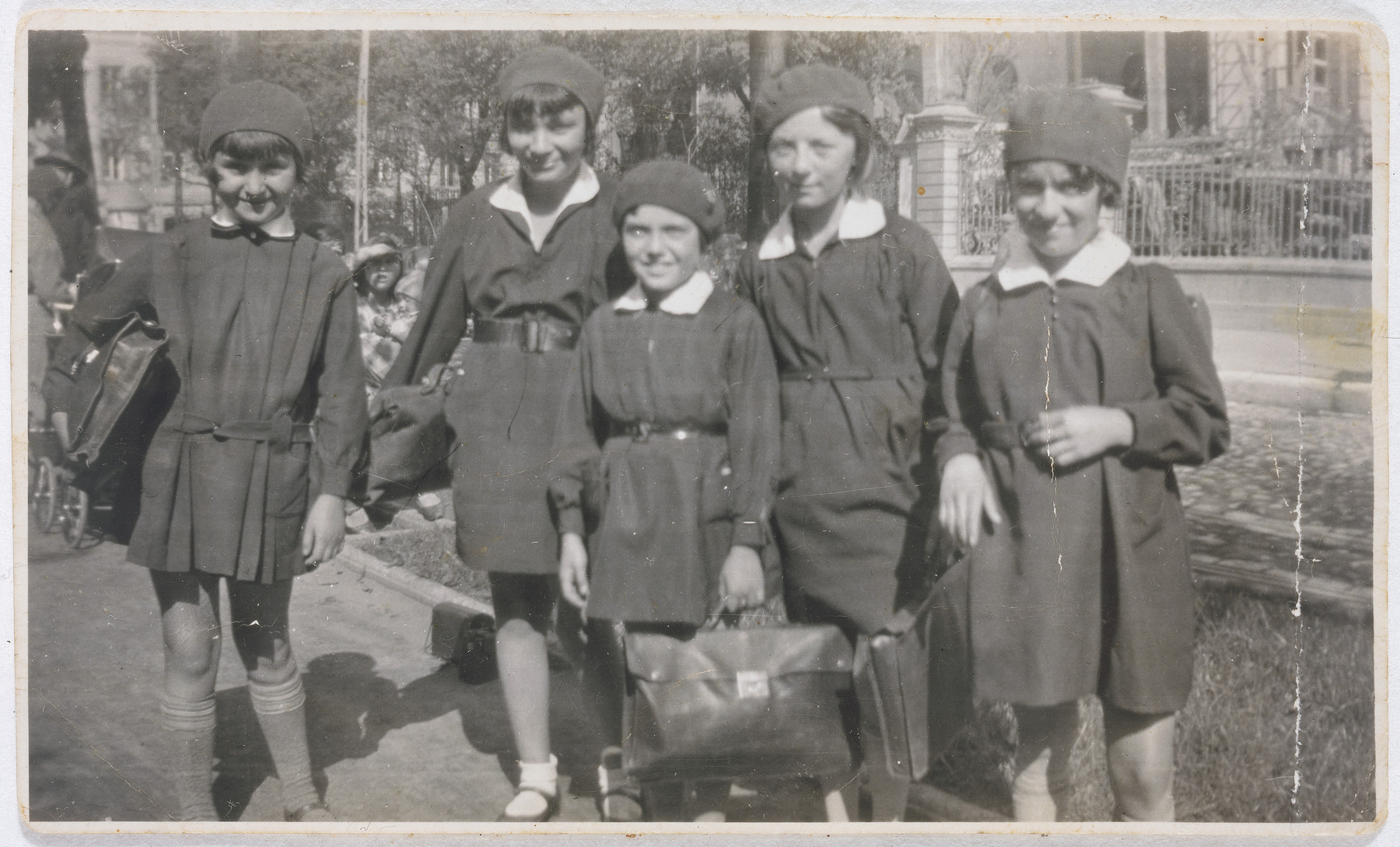 Five girls carry their book bags on their way to the Hochstein Gymnasium in Lodz.

Pictured from left to right are Mindla Reiss, Bronka Rheingold, Marysia Sheinberg, Mira Poznanska, and Bela Ginzburg.    

They graduated from high school in 1938.  The photograph was taken by Fania Ginzburg Rubashkin, Bela's older sister. Bronka Rheingold, Bela Ginzburg and Marysia Sheinberg were killed in the Warsaw ghetto.  Mira Poznanska was murdered together with her husband in Czestochowa.