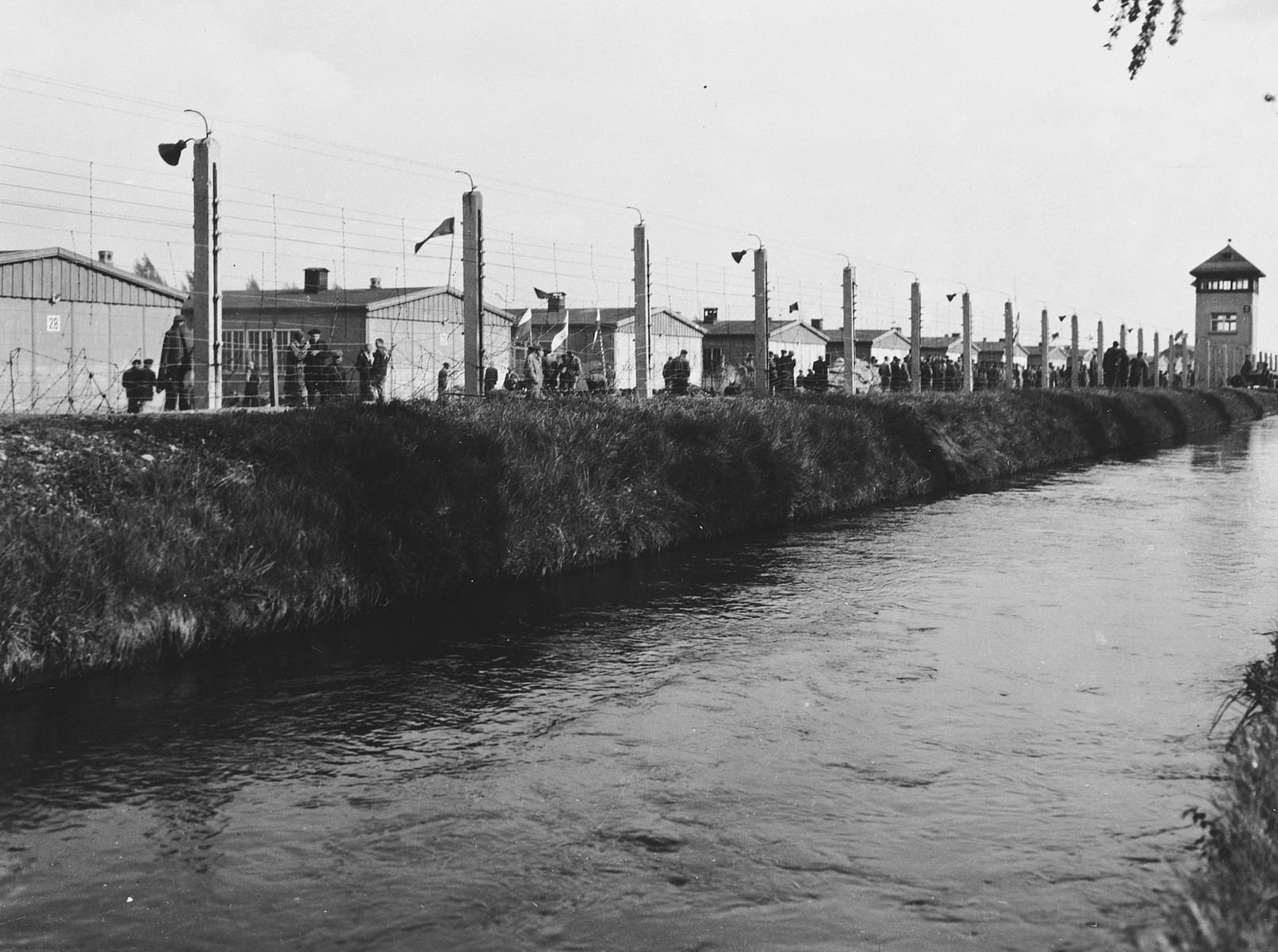 View of the moat in front of the barbed wire fence surrounding the Dachau concentration camp.