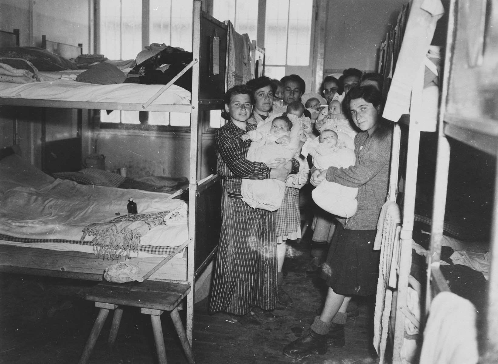 Group portrait of Hungarian Jewish mothers and their infants in a Dachau sub-camp in Germany.   

Pictured left to right are Eva Schwartz with her daughter Maria; Dora Loewy and her daughter Szuszi; Boeszi Legmann with her son Gyuri; Suri Hirsch with her son Yossi; Miriam Schwarcz Rosenthal with her son Laci (Leslie); Magda Fenyvesi with her son Judit, and Ibolya Kovacs with her daughter Agnes.