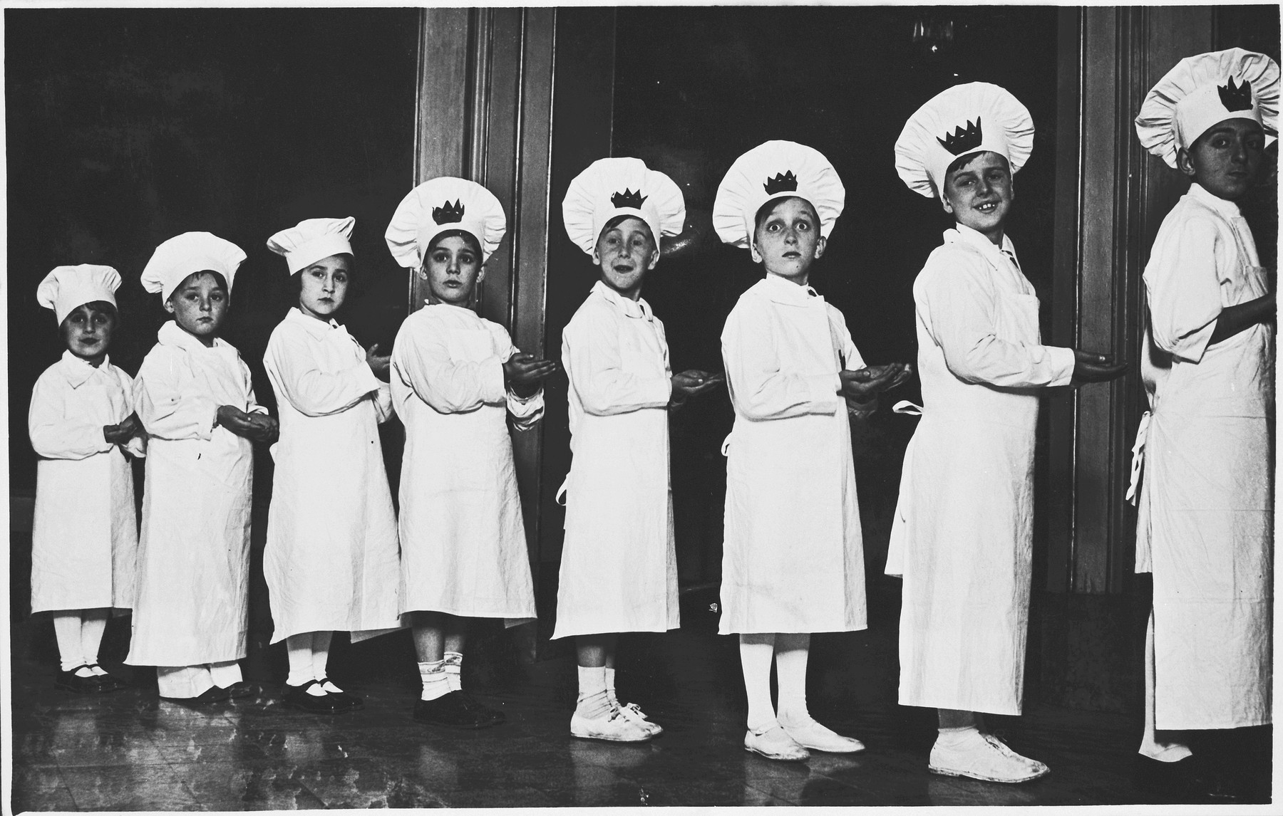 Eight Jewish children wearing Purim costumes stand in a line.

Among those pictured is Sergio Minerbi (second from left).