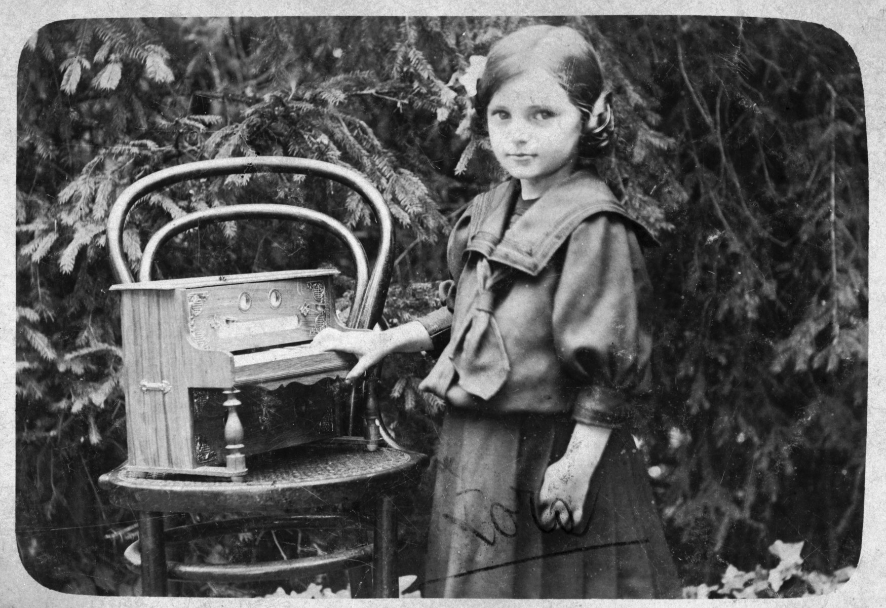 Close-up portrait of a young Jewish girl with a toy piano in a small village outside of Zagreb.

Pictured is Zora Benedik, the mother of the donor.