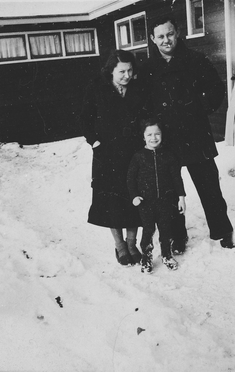 A German-Jewish family poses in the snow outside one of the barracks of the Westerbork camp.

Pictured are Herta and Manfred Fink and their son Michael.