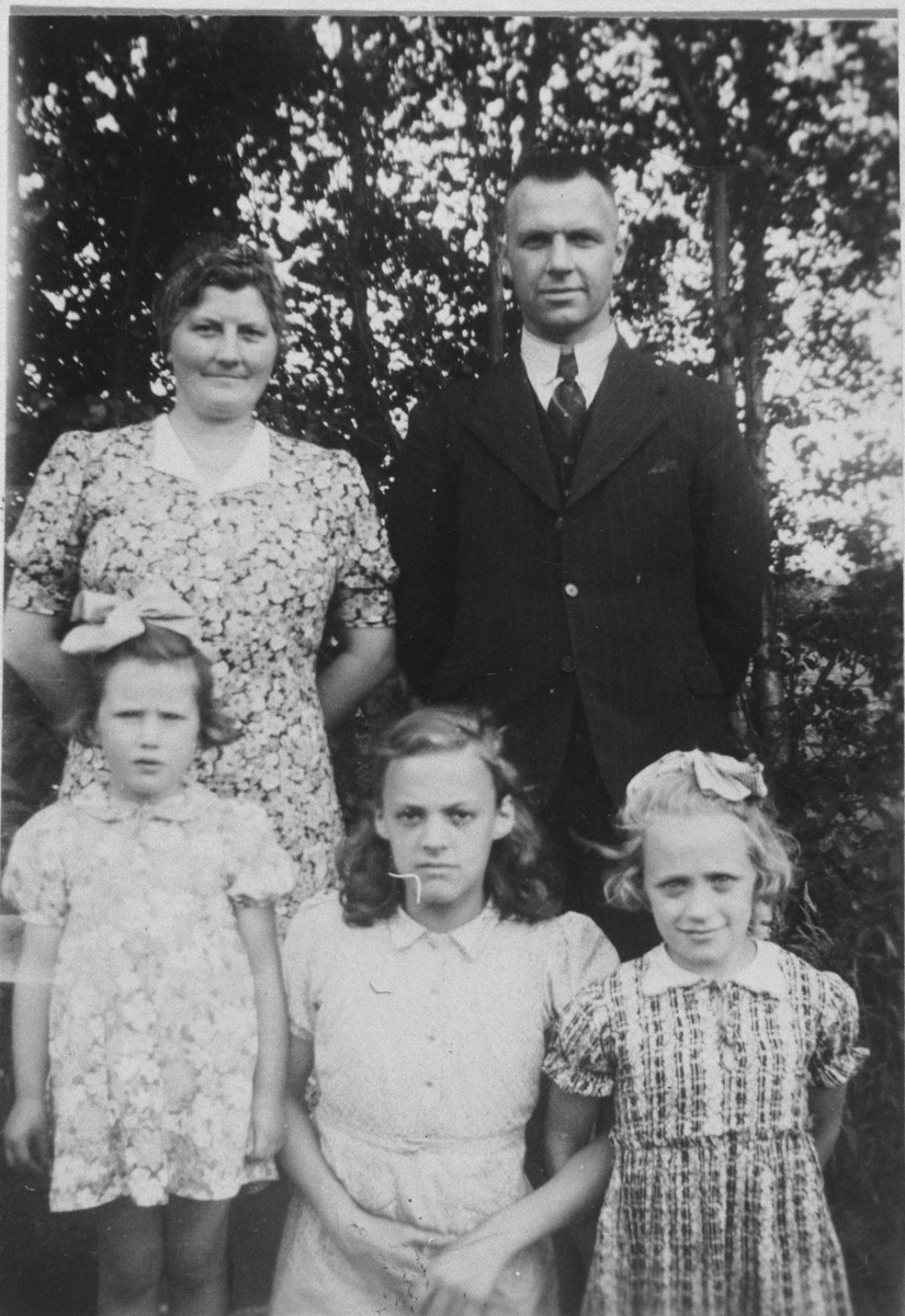 A young Jewish child poses with her rescuers and their foster daughter while in hiding.

Pictured front row are Miep van Engel, Marie Sluimer who was visiting from Amsterdam that summer and Janny Sluimer.  Standing are Dirk and Sjoukje Hellinga.