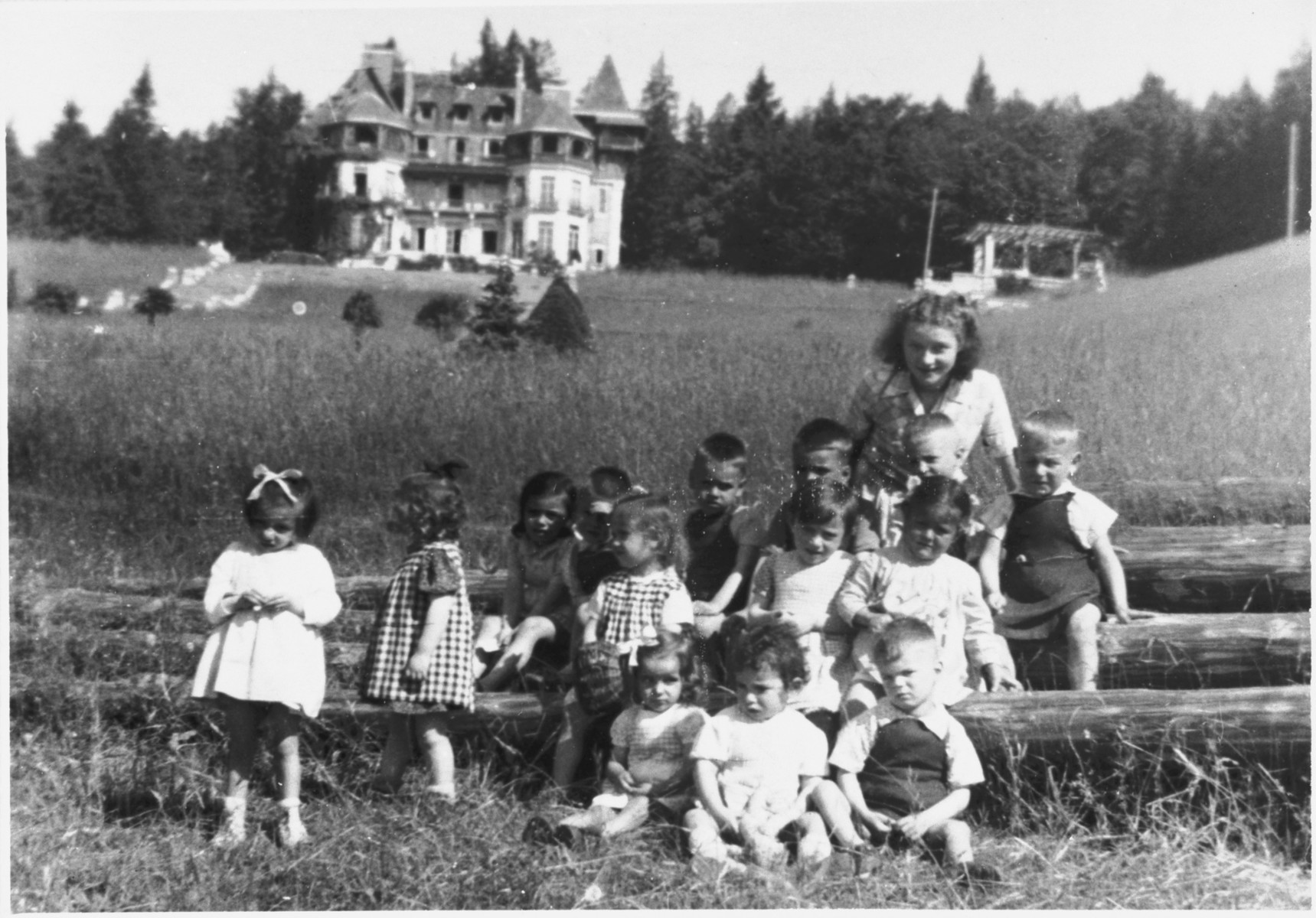 A half-Jewish teenage girl who survived the war in hiding poses with a group of the youngest children in the Chateau des Avenieres children's home in Cruseiles.

Pictured in the back right is Margot Schwarzschild.