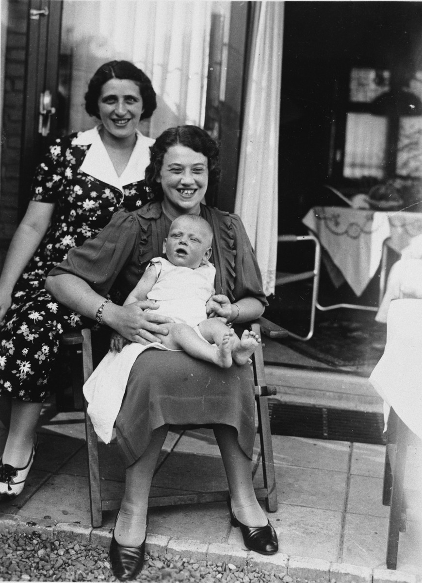 A Dutch Jewish woman holds her newborn baby on her lap outside her home in Eindhoven.

Pictured are Mrs. van Engel and her son, Max.  The other woman is unidentified.