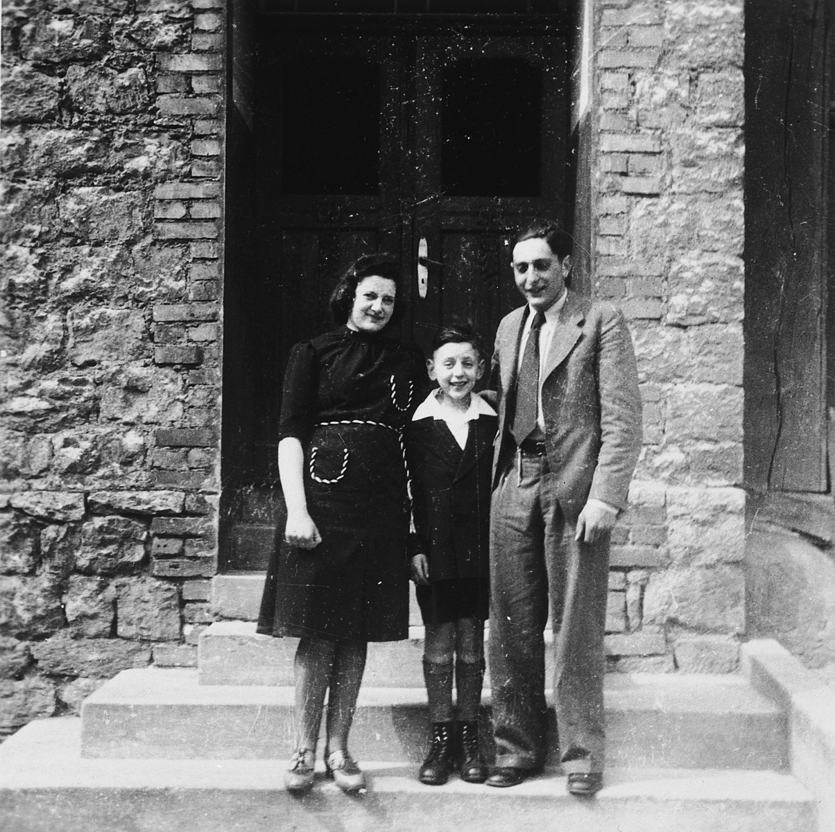 A German-Jewish boy poses outside his home in Rimbeck, Germany with his parents on the occasion of his bar mitzvah.

Pictured are Mathilde, Ludwig and Siegfried Fischel.  Half a year later the family was deported to Riga.