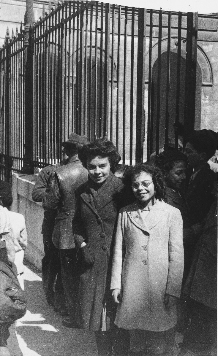 Two Jewish girls stand outside the entrance to the synagogue in Marseilles where an American Jewish chaplain is organizing Passover religious services.

The uncle of one of the girls was a general with the Free French Forces.