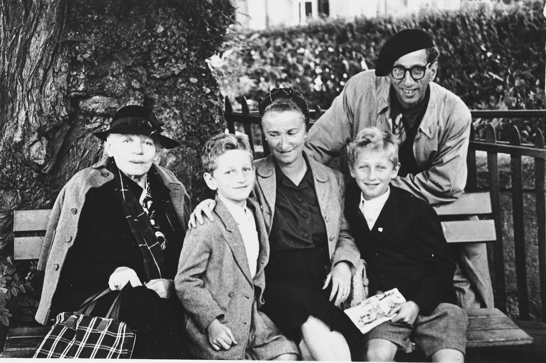 Group portrait of a Jewish refugee family seated on a park bench in Geneva.

From left to right are Renate Hirsch, Claude, Ines Walter and Andre Limot.