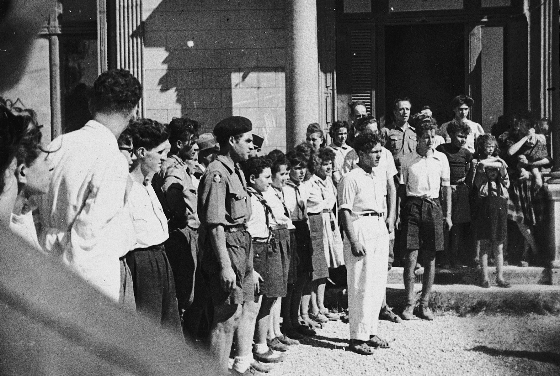 Zionist youth, many in uniform, stand in formation and sing Hebrew ...