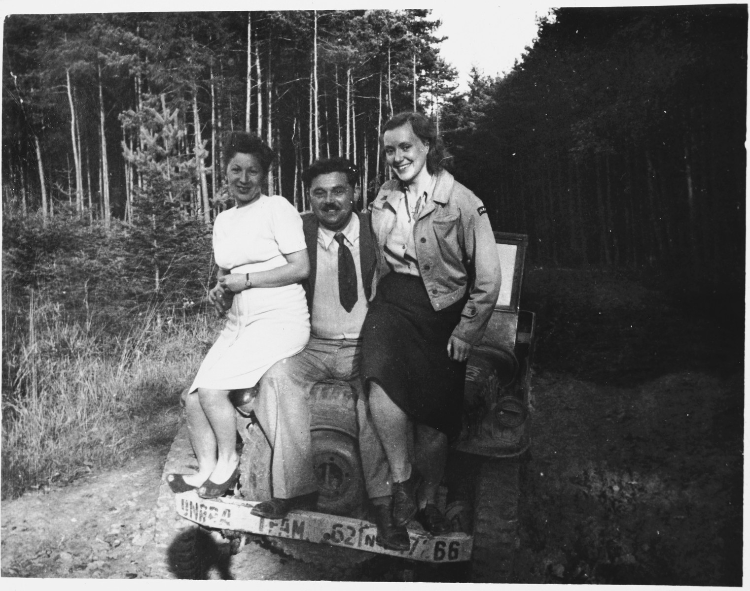 Three UNRRA workers sit on top of a car in the Windsheim displaced persons' camp.

Pictured on the right is Marion Pritchard.