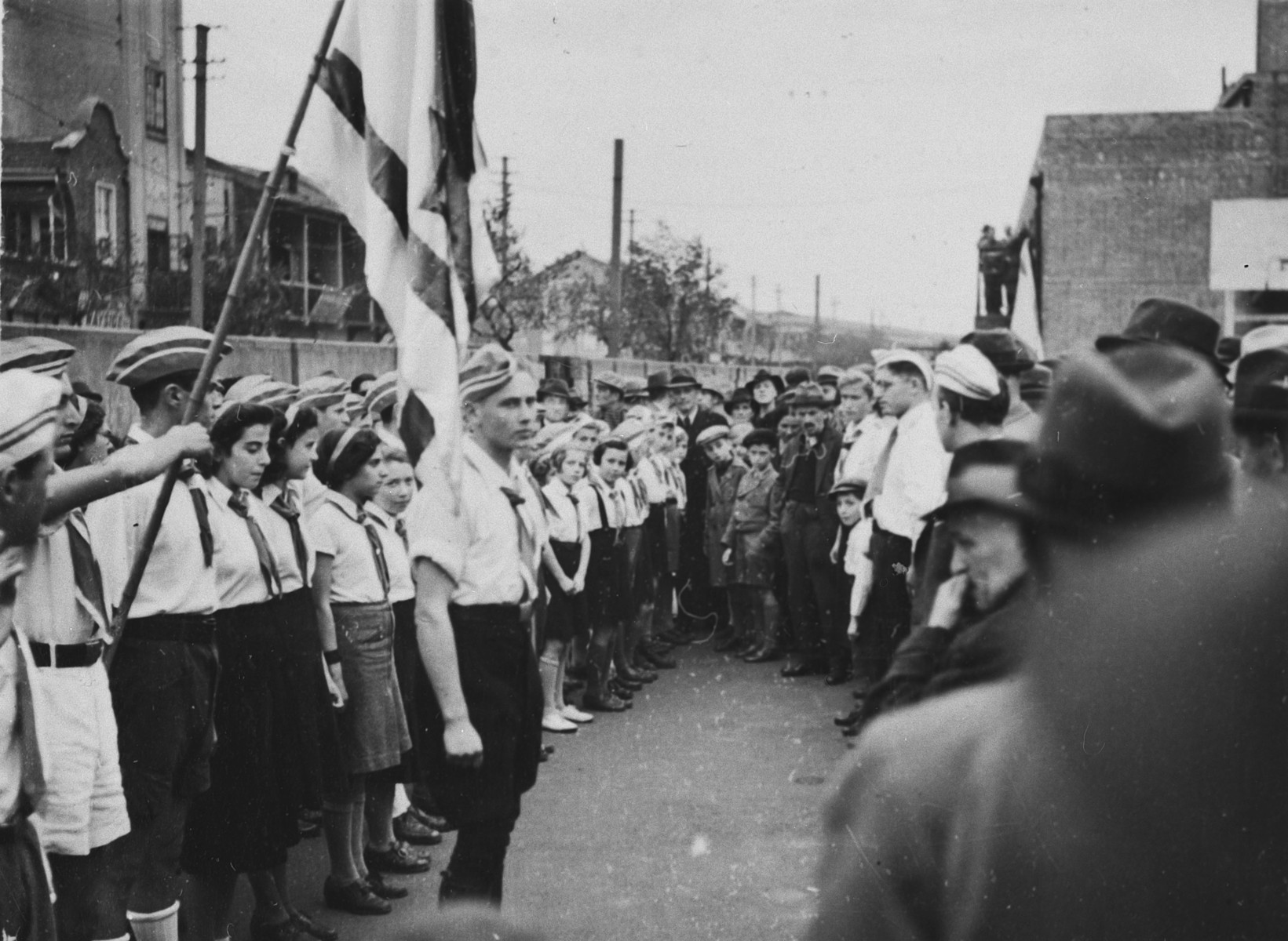 Zionist youth in Shanghai gather in formation with a flag.