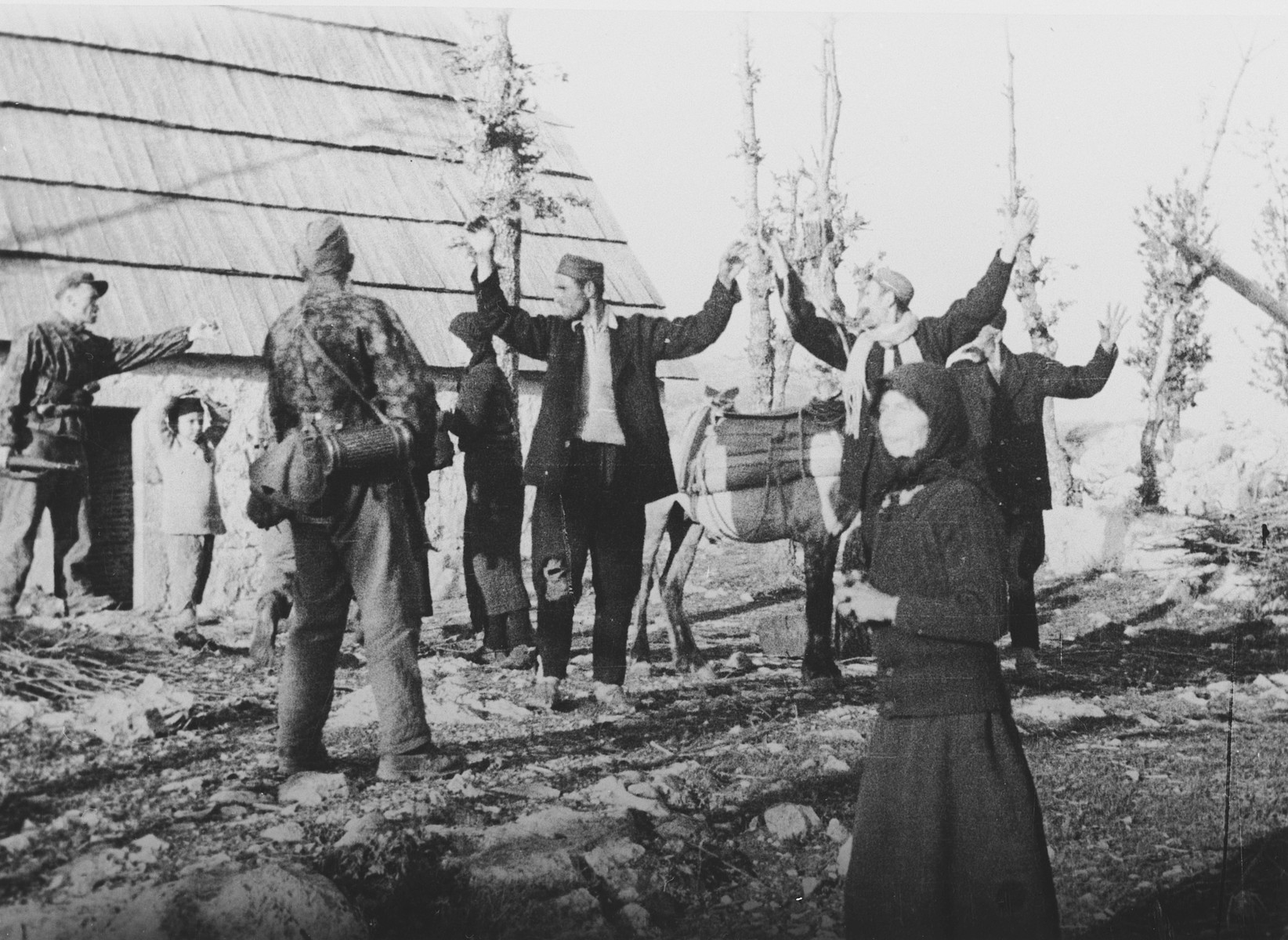 Croatian partisans surrender to German soldiers. 

The original  Waffen-SS caption reads, "Gefangene Partisanen" (captured partisans).

One of a series of photographs taken by the 7th SS Volunteer Mountain Division Prinz Eugen in Croatia, Serbia, and Montenegro from 1942 to 1944, after the German invasion of the Kingdom of Yugoslavia. The photographs are believed to have been captioned by the commanding office of the Waffen-SS, and had been in the possession of  Friedrich Wilhem Krueger, who served with the division from November 1943 until April 1944.