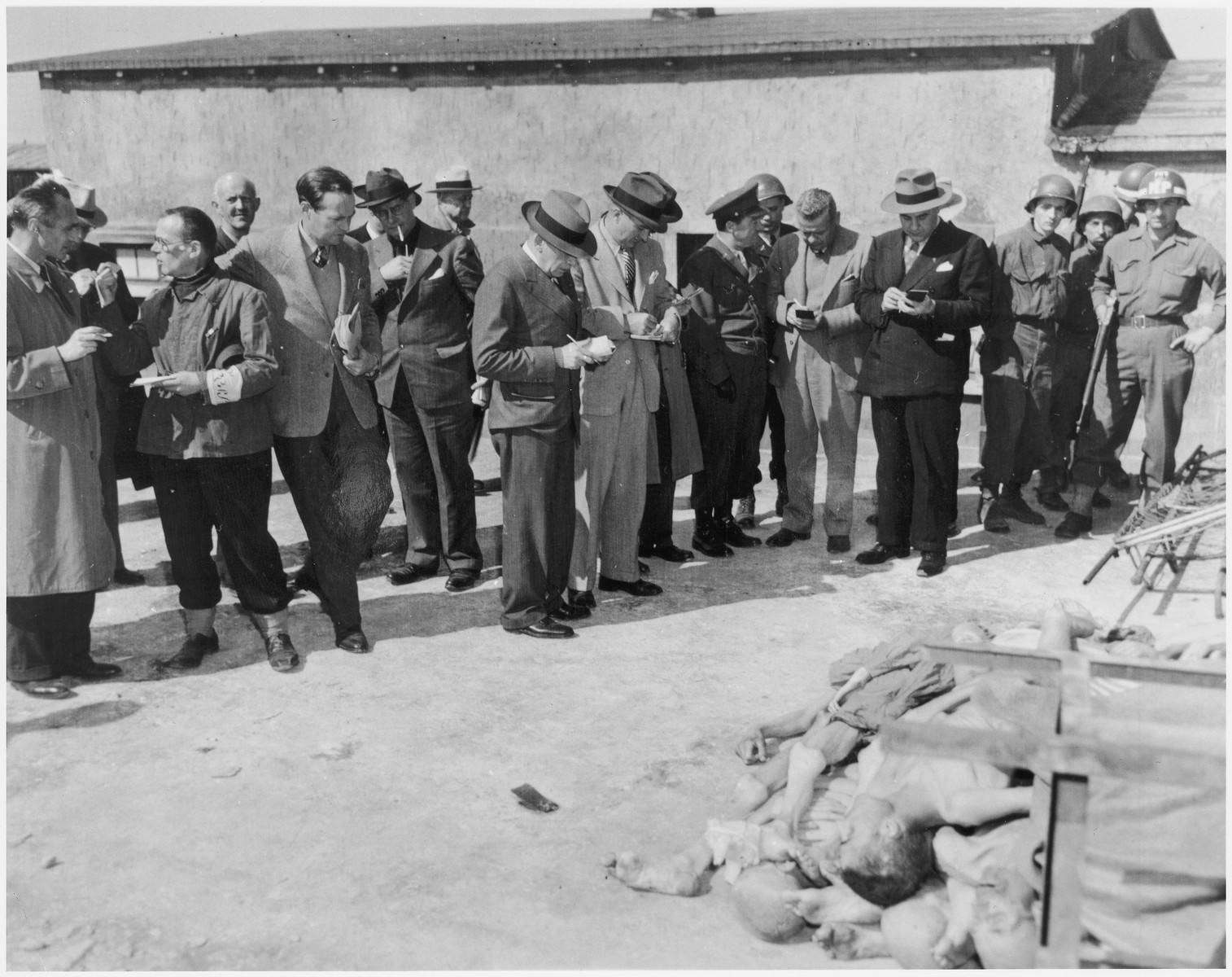 Journalists, accompanied by American military police, conduct an inspection tour of the newly liberated Buchenwald concentration camp.