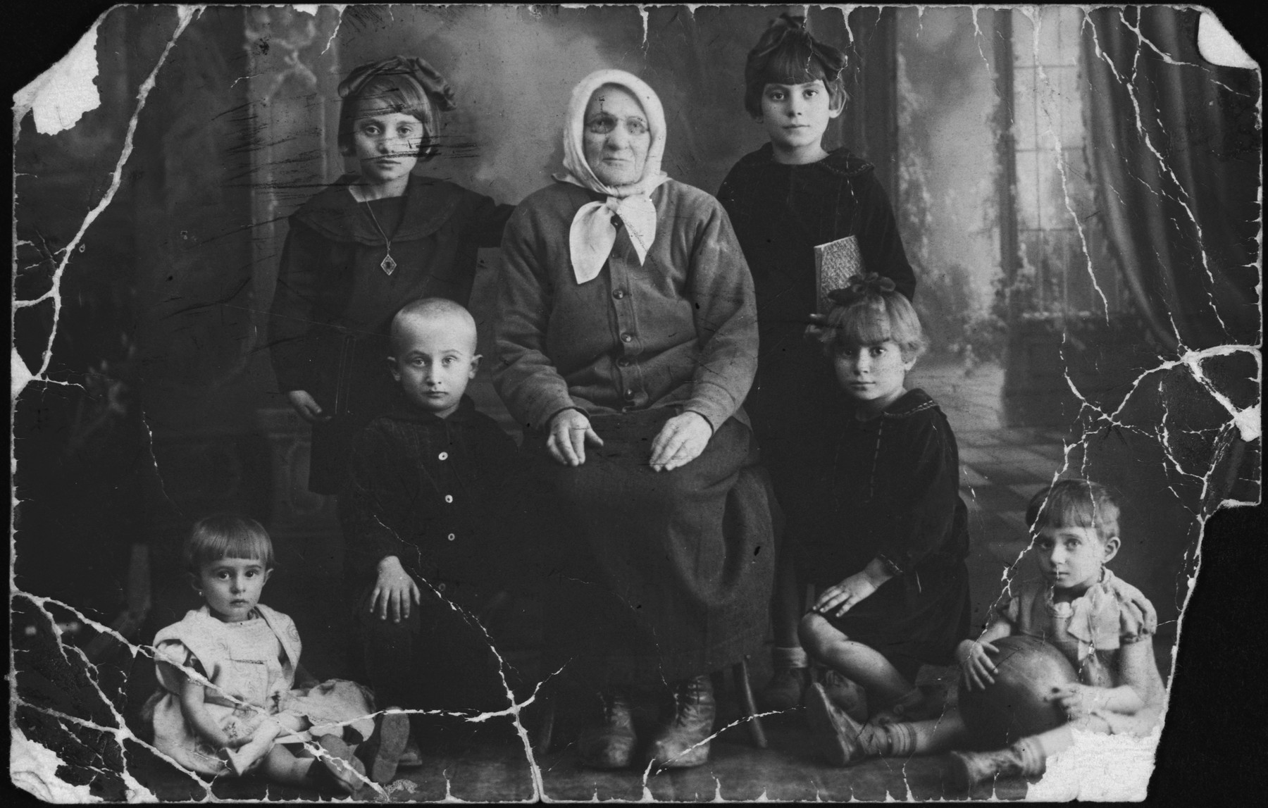 Studio portrait of a Jewish family in Pruzhany.  All pictured perished in the Holocaust.

The original caption reads "Two girls are daughters of Rifke.  My grandchildren.  The little boy is Rifke's grandchild.  The little girl is Tsiri's; the second girl is Berl's.  In memory from your grandmother, Shayne Khayes."