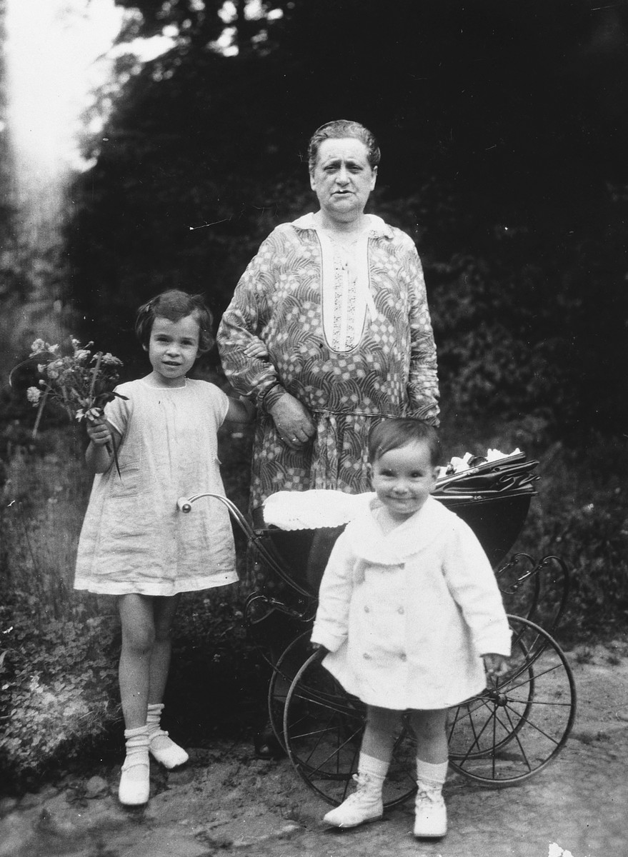 Two young sisters pose with their grandmother next to a baby carriage in the park.

Pictured are Ursula and Gerti Totschek with their grandmother, Minna.