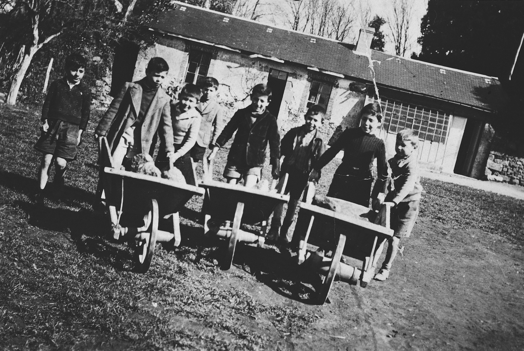A group of children pushes wheelbarrows on the grounds of the Masgelier children's home in France.

Among those pictured is Israel Lichtenstein.