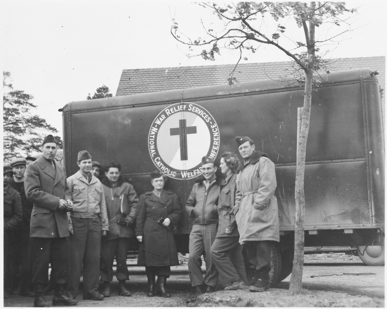 UNRRA workers stand next to an ambulance supplied by the National Catholic Welfare Conference (probably in the Foehrenwald displaced persons' camp).

Marion van Binsbergen Pritchard is pictured second from the right.