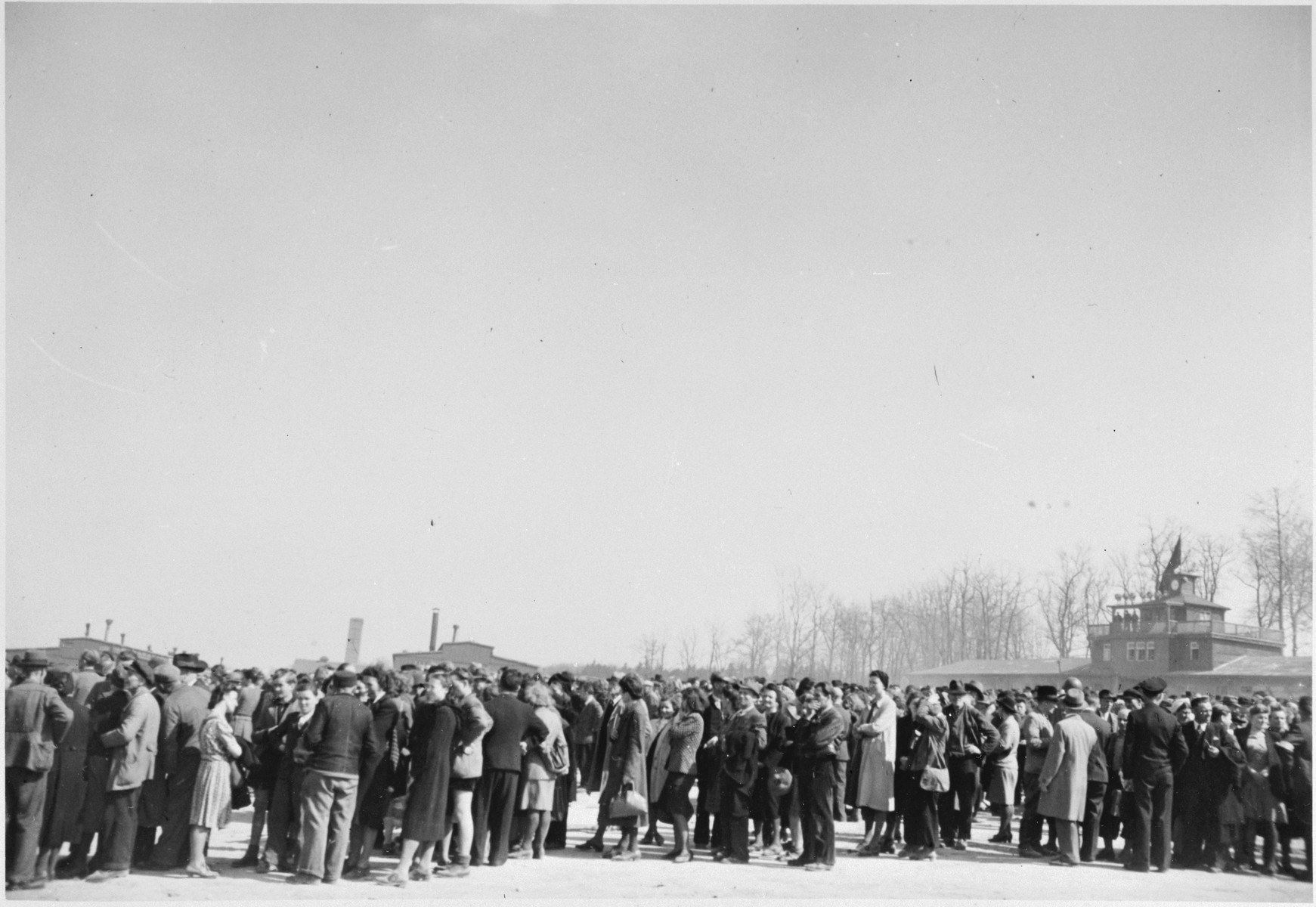 German civilians are forced to wait in-line to tour the Buchenwald concentration camp.

The original caption reads, "General Patton requested that over 1200 residents of Weimar visit the camp [Buchenwald] and see the horrors which had been wrought upon the political prisoners by the Gestapo".
