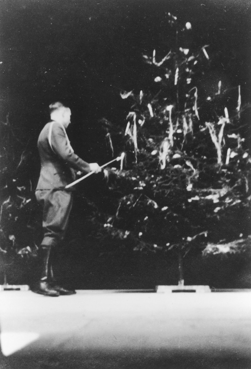 SS officer Karl Hoecker lights a candle on a Christmas tree only weeks before the liberation of Auschwitz. 

The original caption reads "Julfeier 1944" (the Nazi name for a pre-Christian Yule celebration).