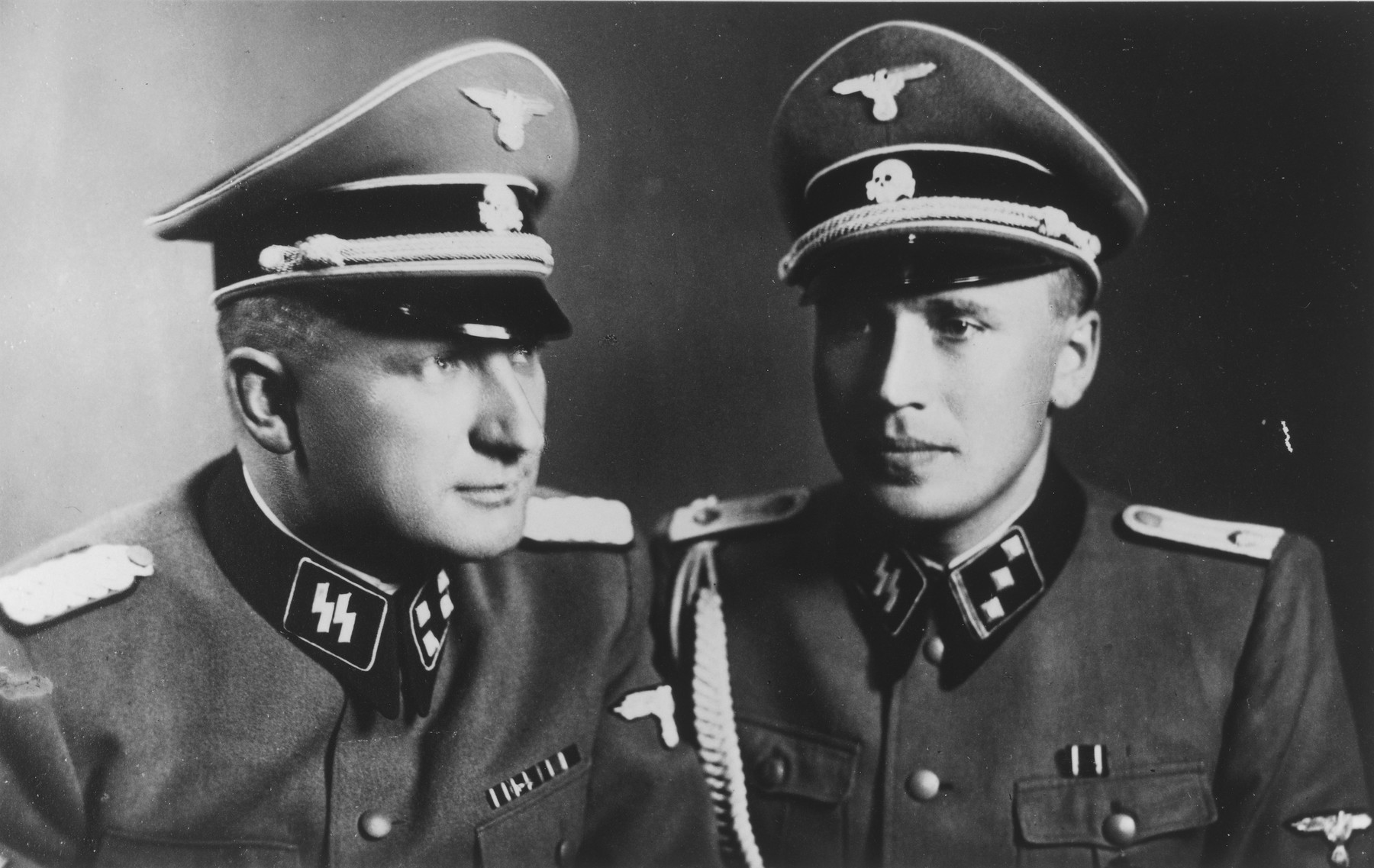 Studio portraits of SS officers Richard Baer and Karl Hoecker. 

The original caption reads "With the Commandant SS Stubaf. Baer, Auschwitz 21.6.44"