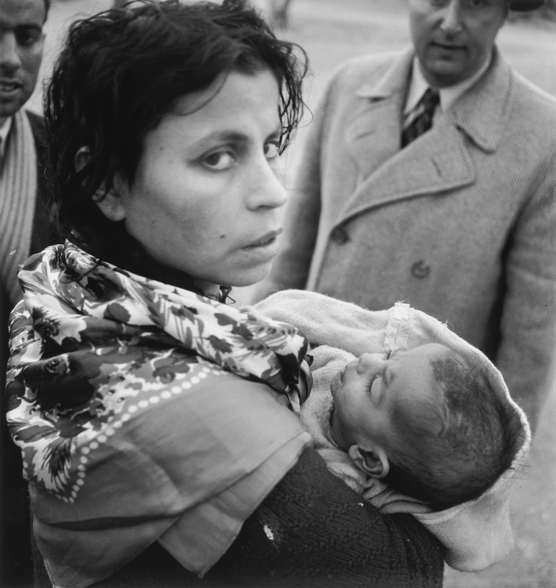A young Morrocan-Jewish mother cradles her infant in her arms in the Los Arenas camp while waiting to immigrate to Palestine.