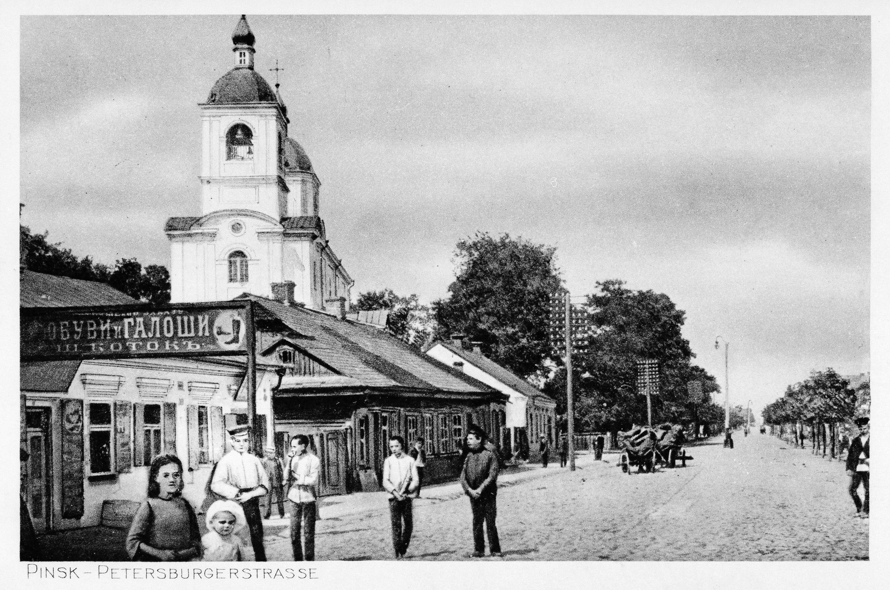 View of a street in prewar Pinsk with signs in Russian.

The original German caption reads "Pinsk -- Petersburgerstrasse".