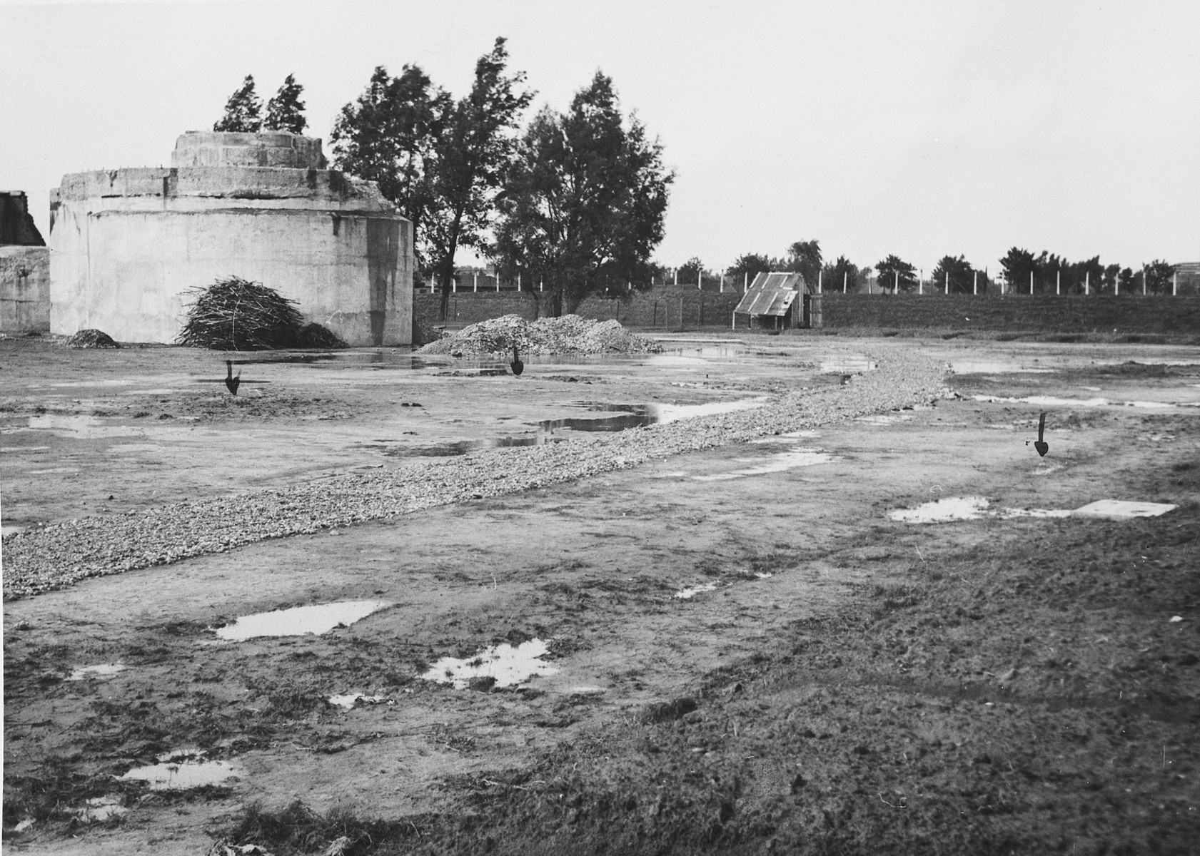 View of the prison yard in the Breendonck concentration camp.

The orginal caption reads, "The red arrows indicate soft earth which has been dug up to find whether or not any bodies were buried there.  Nothing was found."