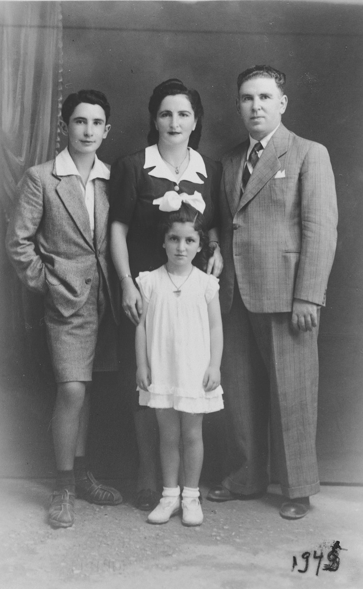 Studio portrait of a Greek-Jewish family taken in their home city of Agrinion after they returned from hiding.

Pictured are Esther and Leon Matsas and their children, Michael and Ninetta.