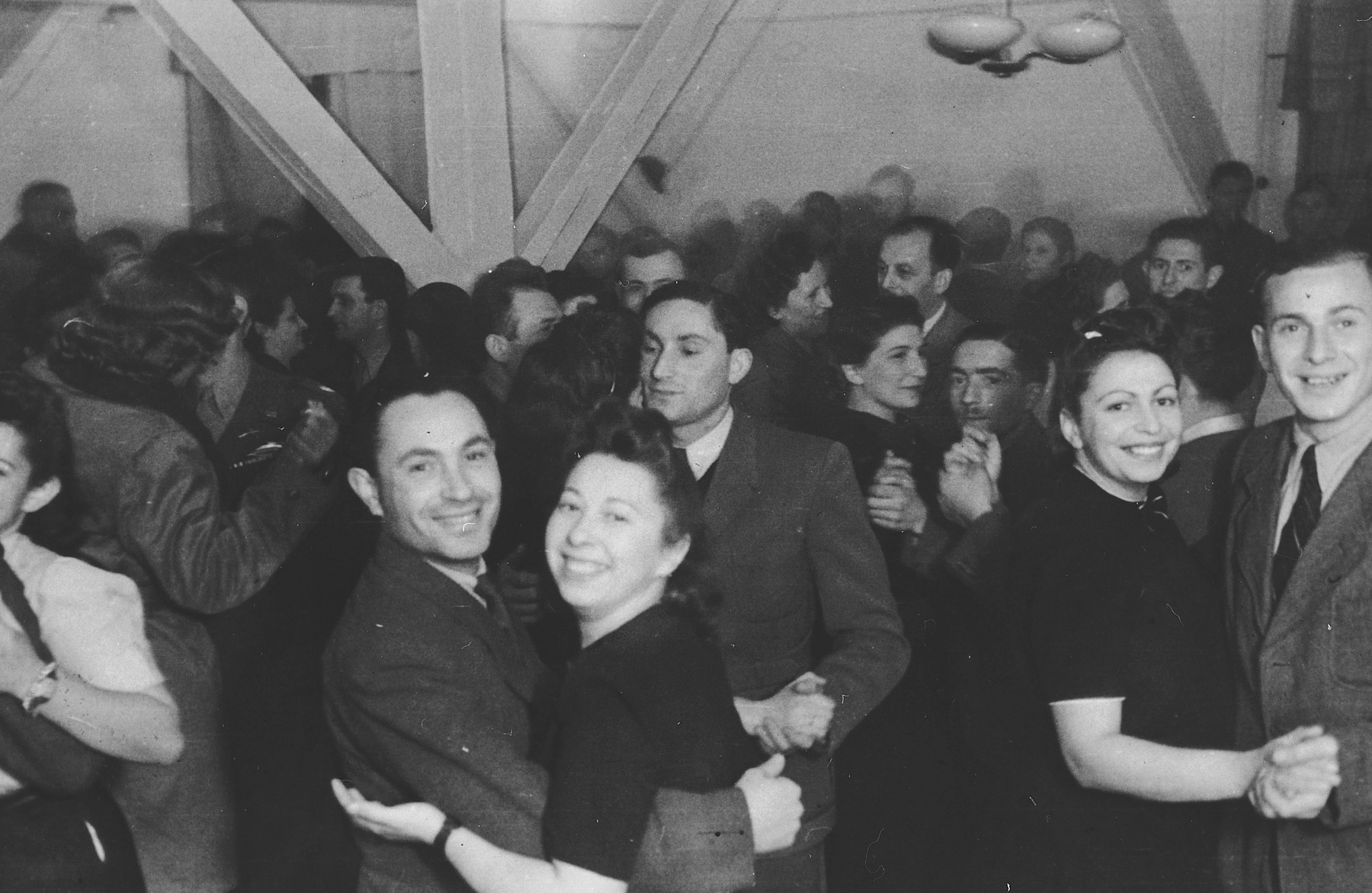 Couples in the Landsberg DP camp dance in a large public hall.