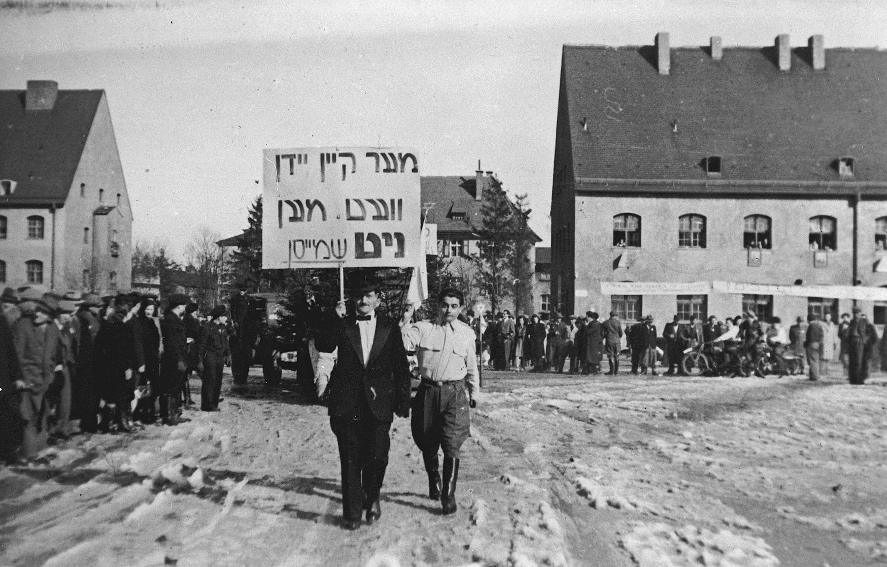 Jews in the Landsberg DP camp march in a Zionist demonstration carrying a banner proclaiming "No longer will Jews be whipped."