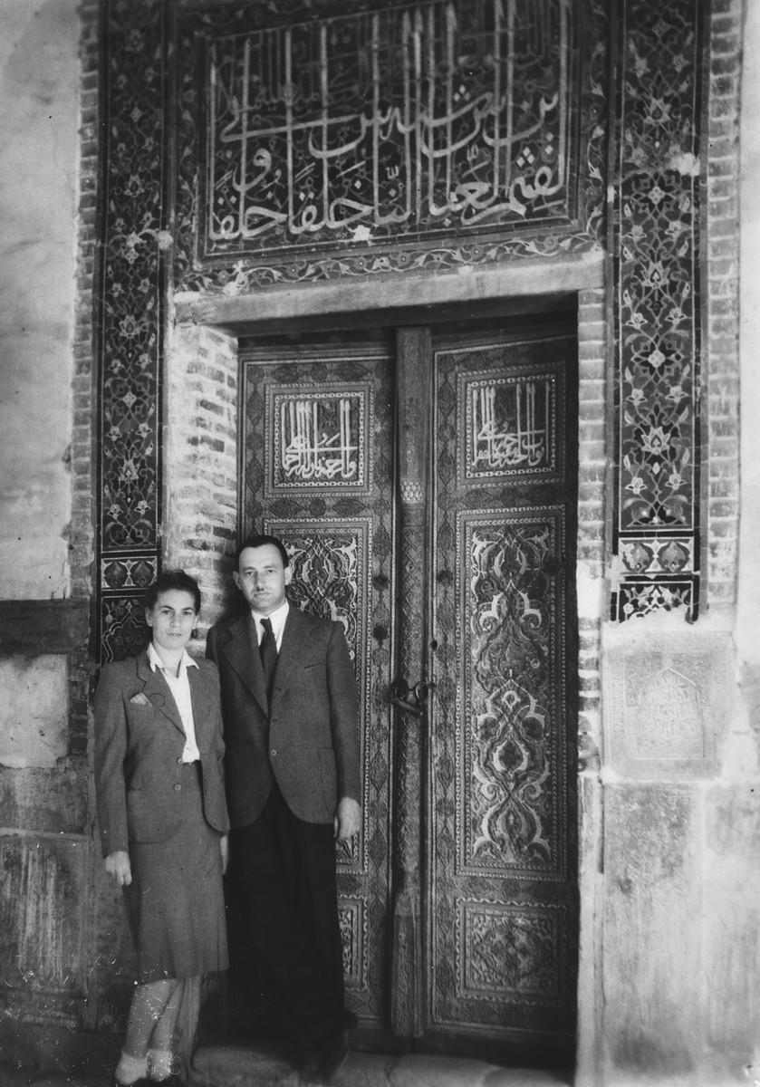 Close-up of a Jewish refugee couple in Samarkand outside a building with Moorish architecture, the tomb of Tamarlane.

Pictured are two Jewish refugees Henryk and Hanka Starski, friends of the donor.
