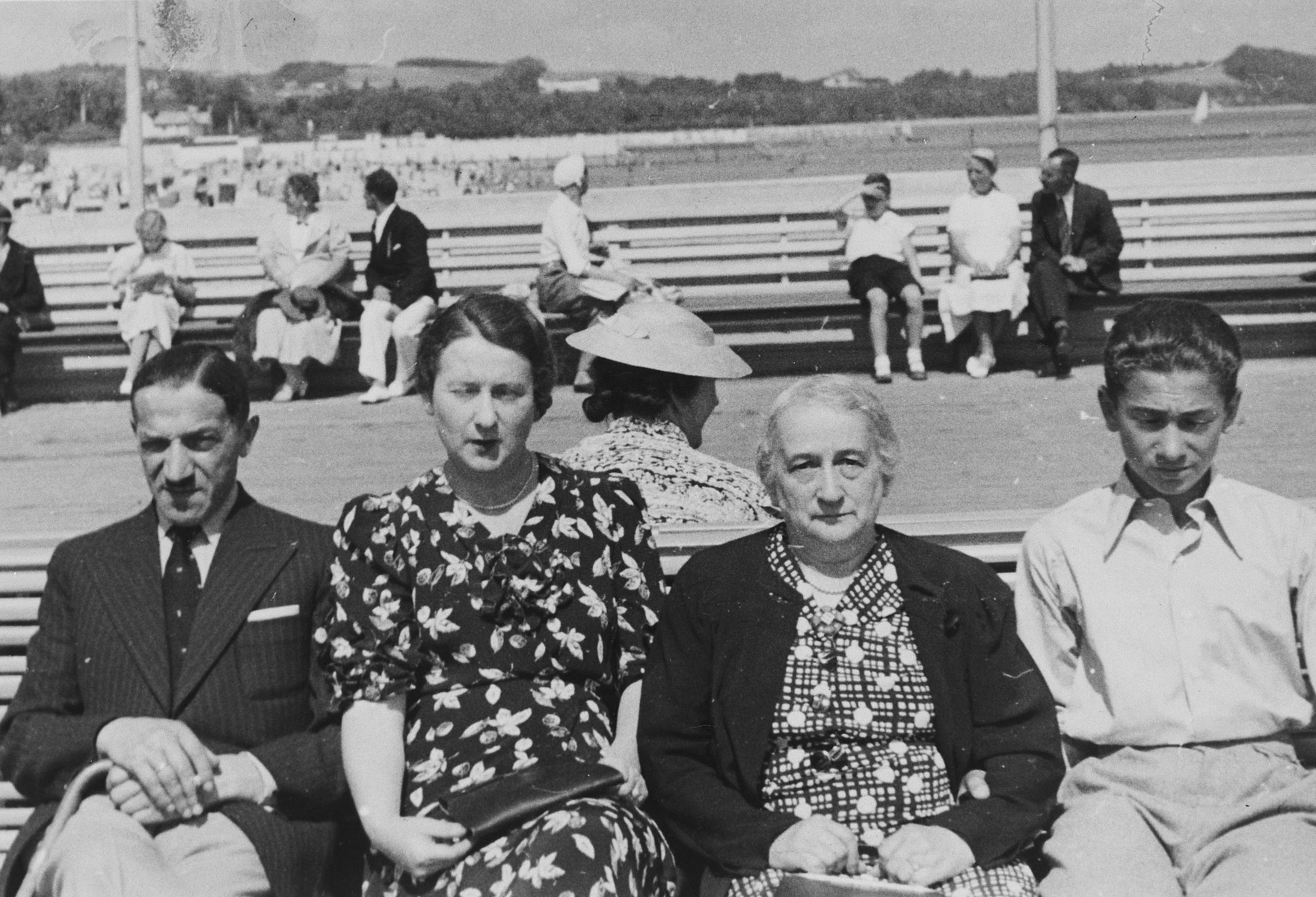 A Polish-Jewish family poses on outdoor benches while on vacation in Sopot.

Pictured from left to right are Julian Ratner, Gustava Ratner, Berta Szrajer, and Marjan Ratner.