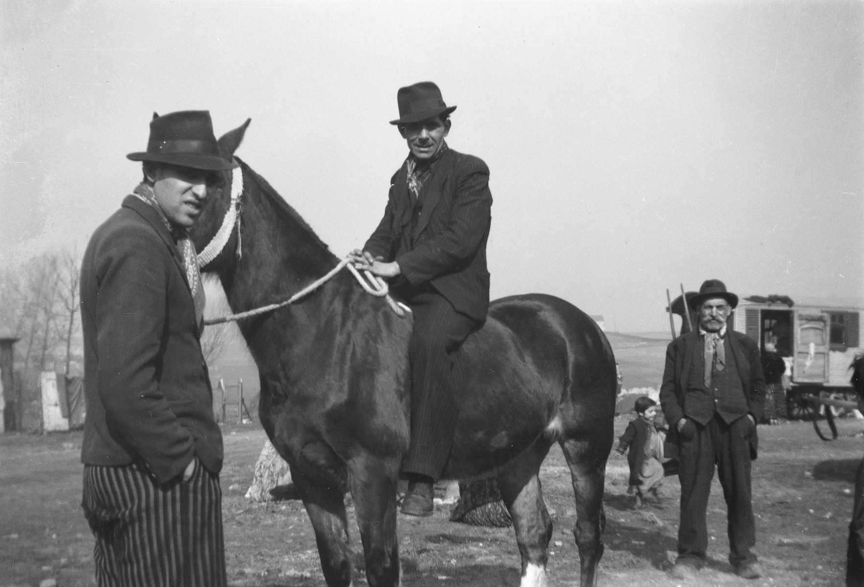 A Romani man sits astride a horse, as others look on.

The caption in "The Heroic Present" reads, "Europe, 1930s."