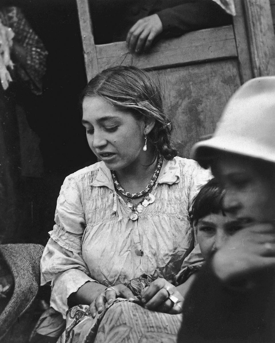 Portrait of a young Romani woman gazing  downward.