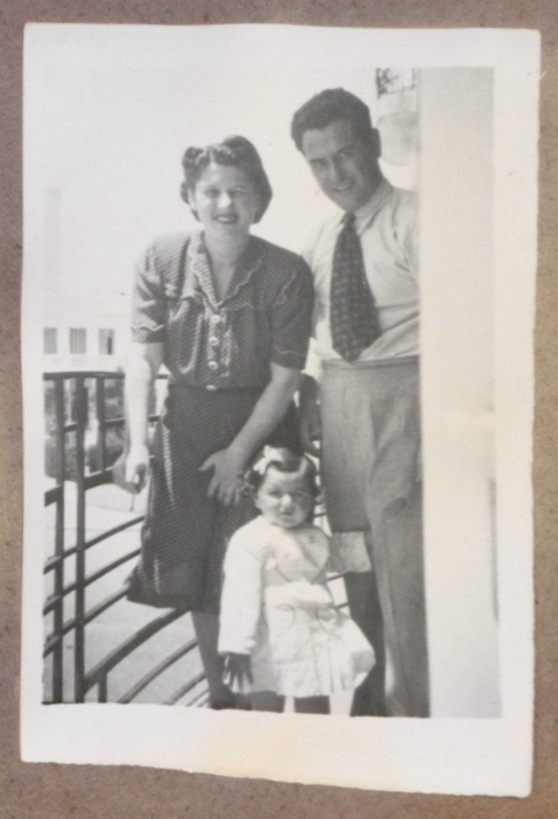 Photo album page showing Daisy Breuer in arms of her mother (Lilly Breuer) and father (Dr. Theodore Breuer) on balcony of apartment Muhammed V Blvd,,Tangiers.