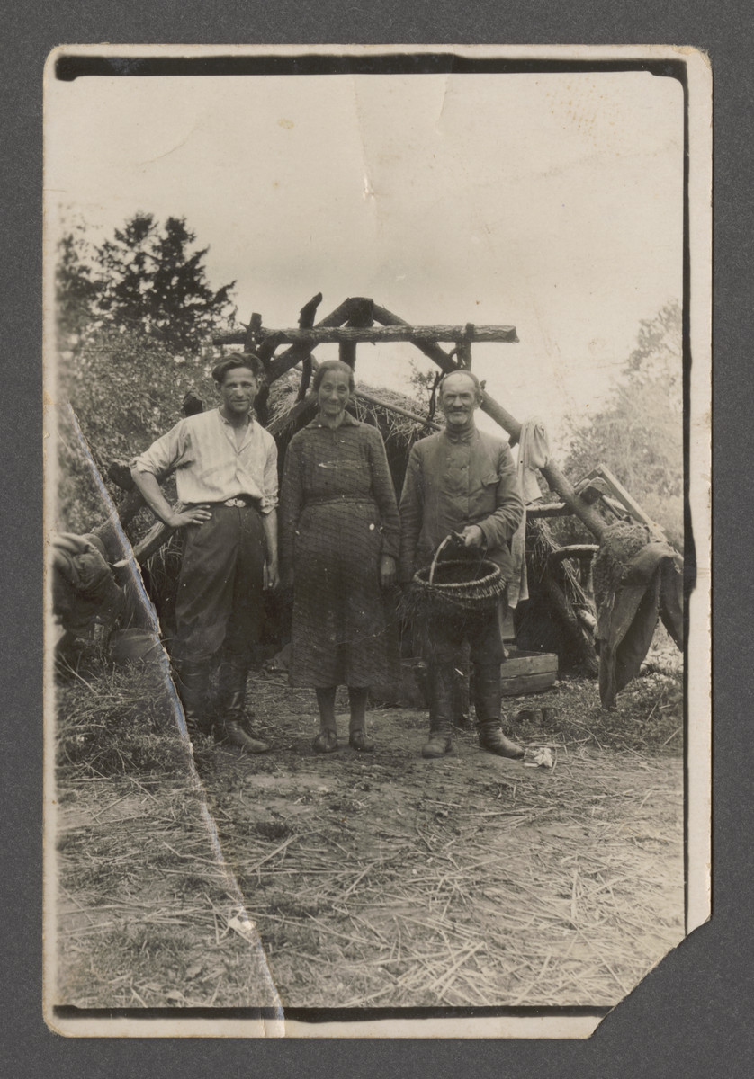 Leah and Joseph Szwarcman and an unidentified younger man stand by a well on the farm [possibly a hachshara] "Chodessah."