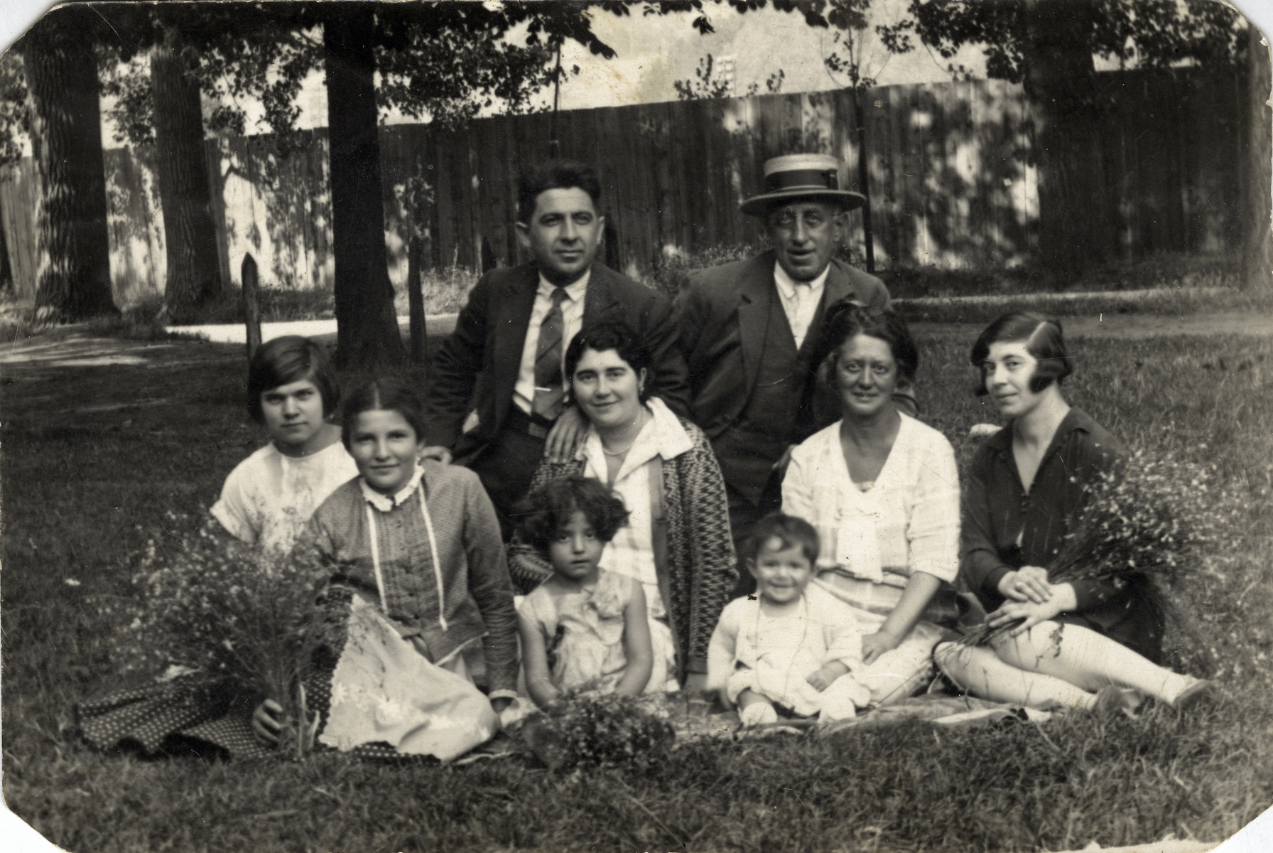The Manojlvic family poses outside with their children and governesses.

Pictured are Izak Manjlovic, and his sisters Milla (far right), and Rasha (3rd from the right), with their children and governesses. Rasha and her children perished during the Holocaust.