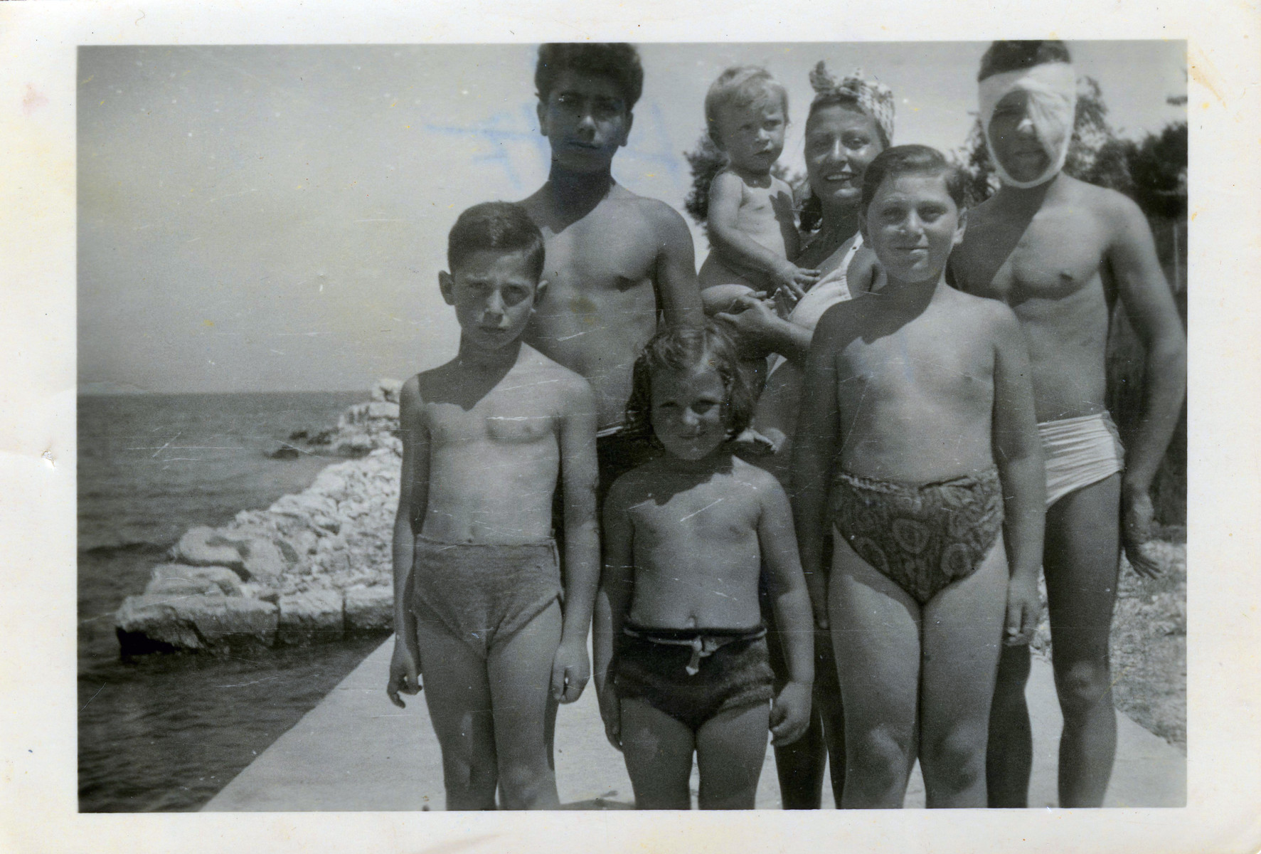 A group of survivors pose on the beach after the war.

Joseph Manojlvic is the tall child on the left.  The child on the left is a non-Jewish survivor who was wounded in the eye.