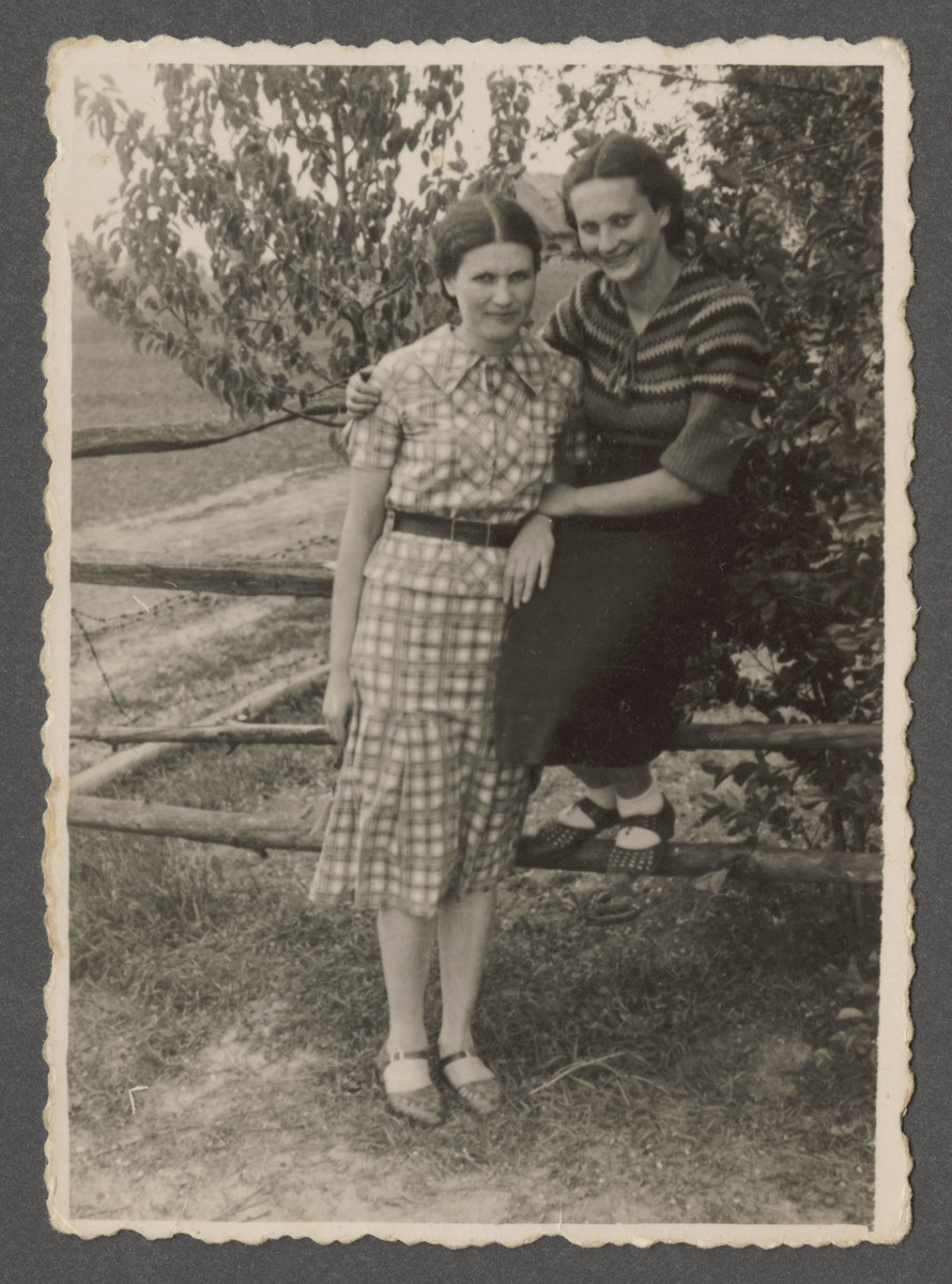 Fania and Sonia Szwarcman poses by a wooden fence in prewar Aleksandria.
