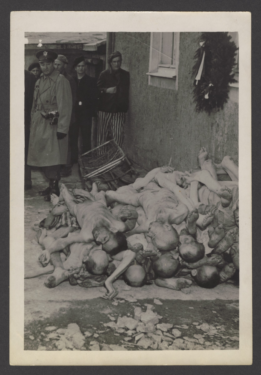 American soldiers and survivors view corpses stacked near the crematoria at Buchenwald.

The inscription on the back of the photograph reads, "Buchenwald."