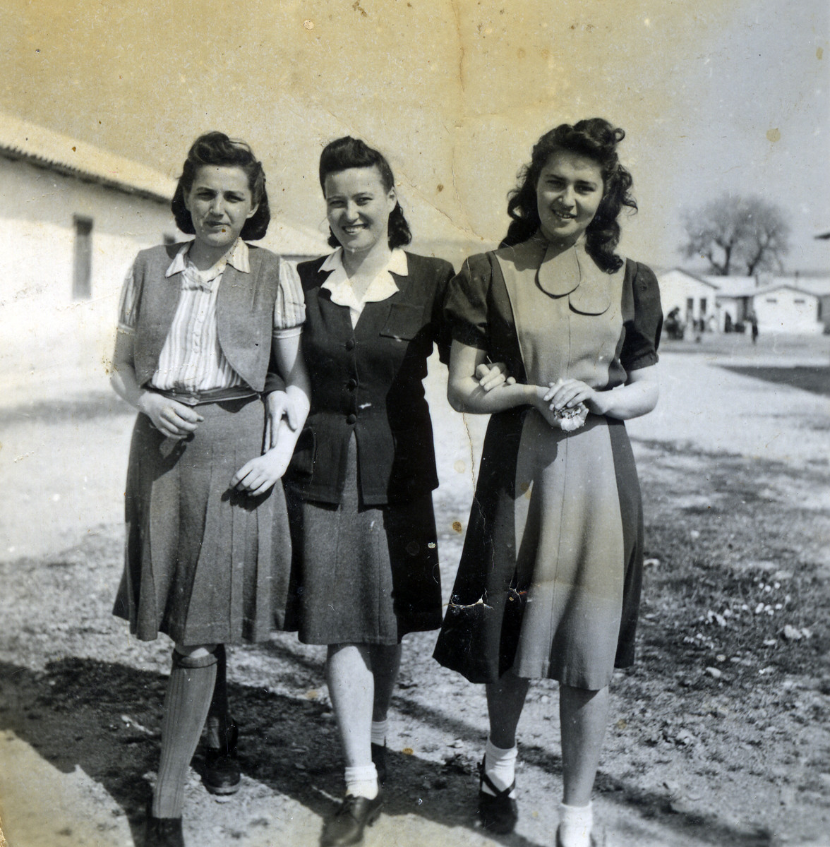 Ruzena Hellinger (nee Blueh) (in the middle) walks with two women in Ferramonti.