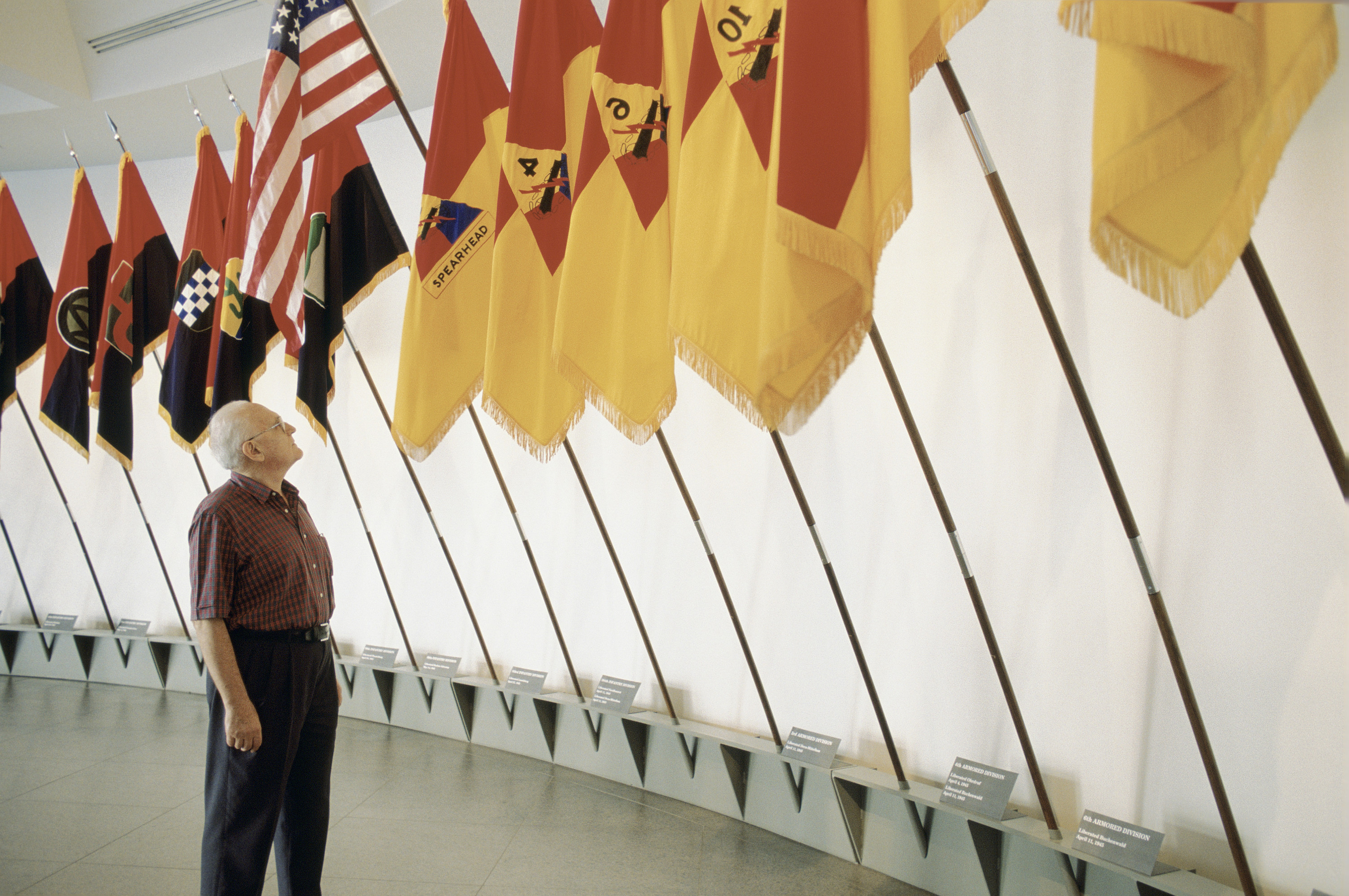 A visitor views the liberation flags installed in the lobby of the 14th Street entrance of the U.S. Holocaust Memorial Museum.